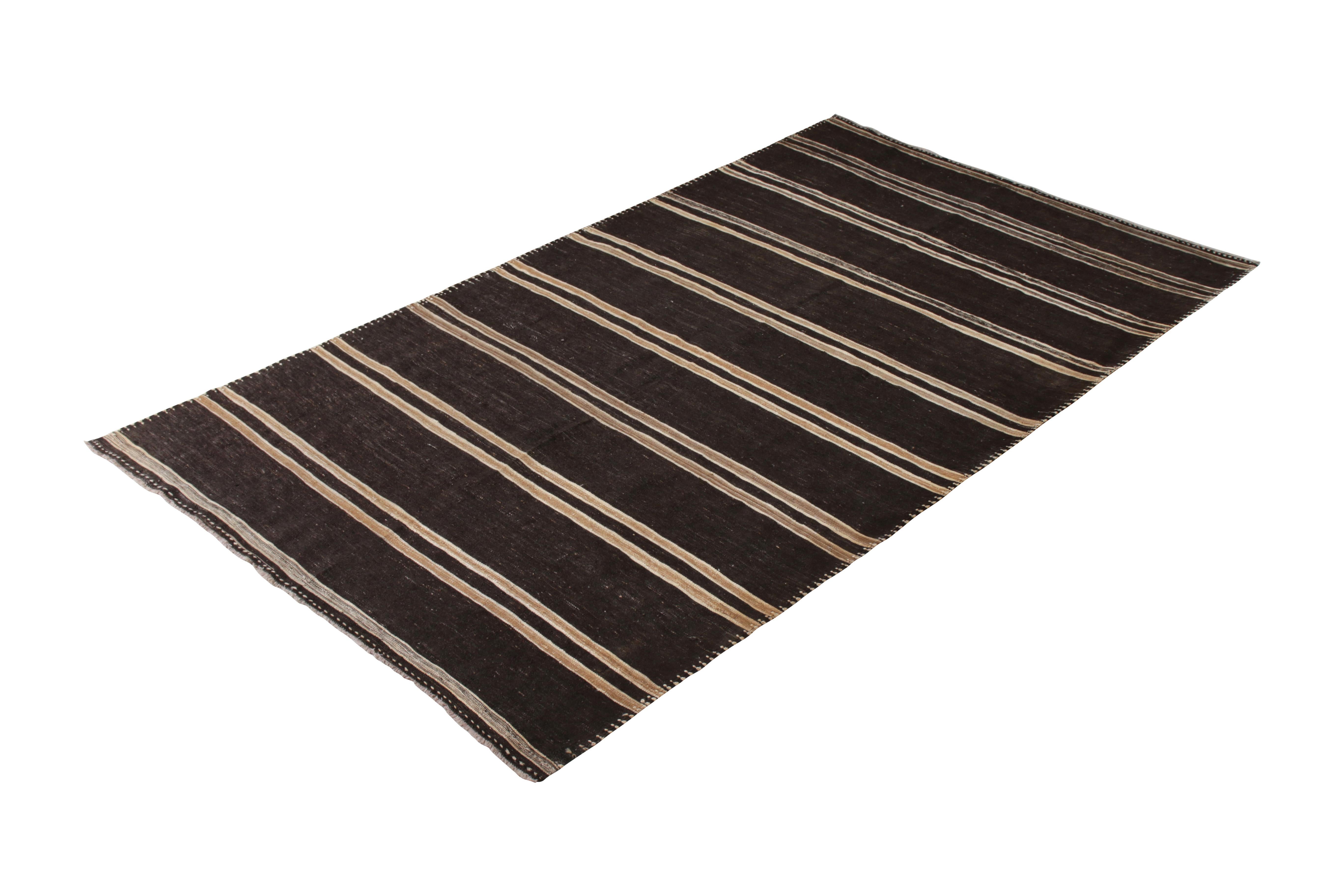 Handmade in a wool flat-weave originating from Turkey circa 1950-1960, this vintage rug is a midcentury Kilim of comfortable color with a complementary striped pattern in a rare 7 x 12 size—well suited in these dimensions to a wider array of