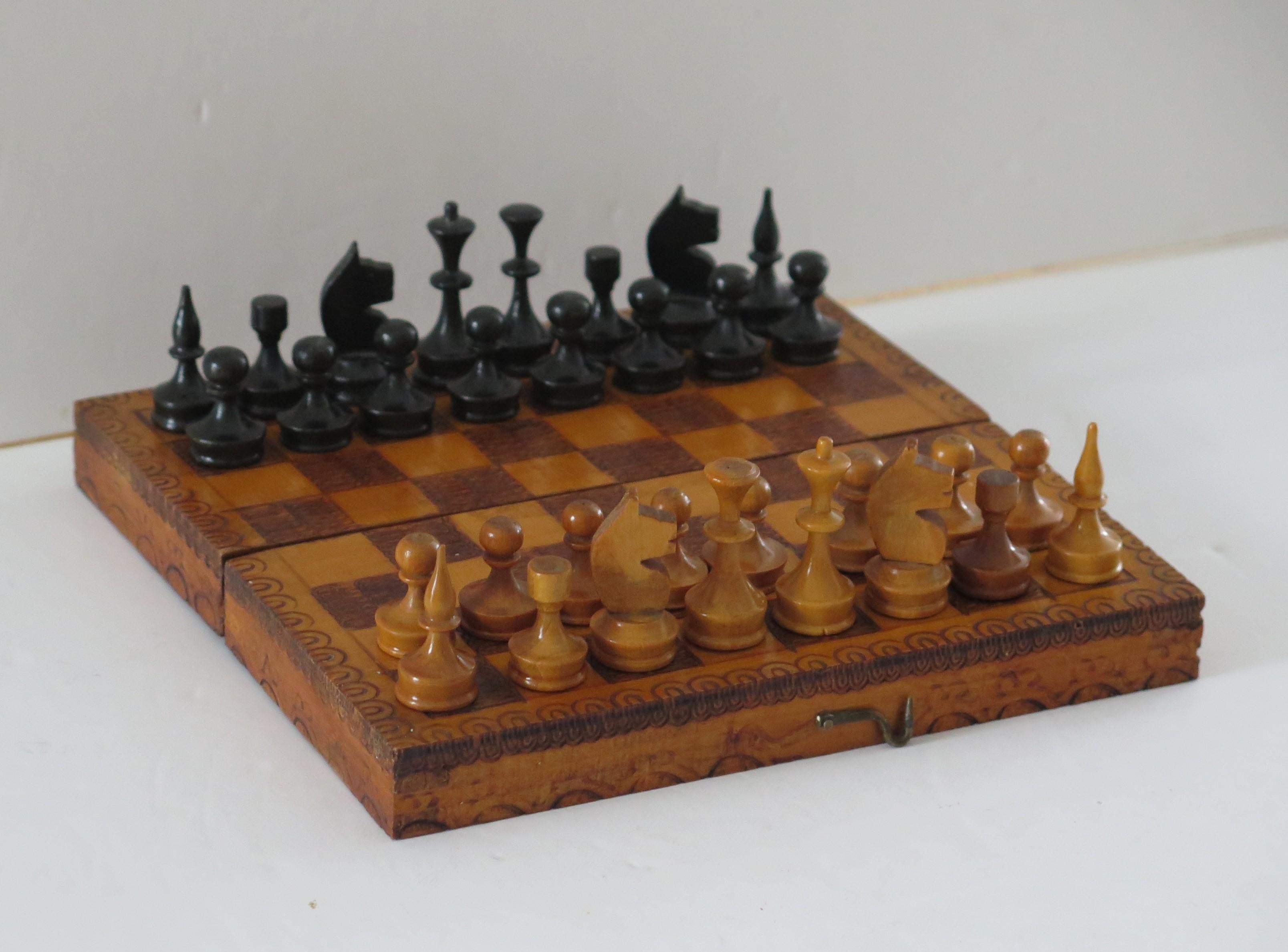 This is a high quality handmade Miniature or travelling wood chess set game of 32 pieces in its own lidded pokerwork decorated box, which we date to the English Edwardian period, circa 1900.

This piece is all handmade. The chess set is complete