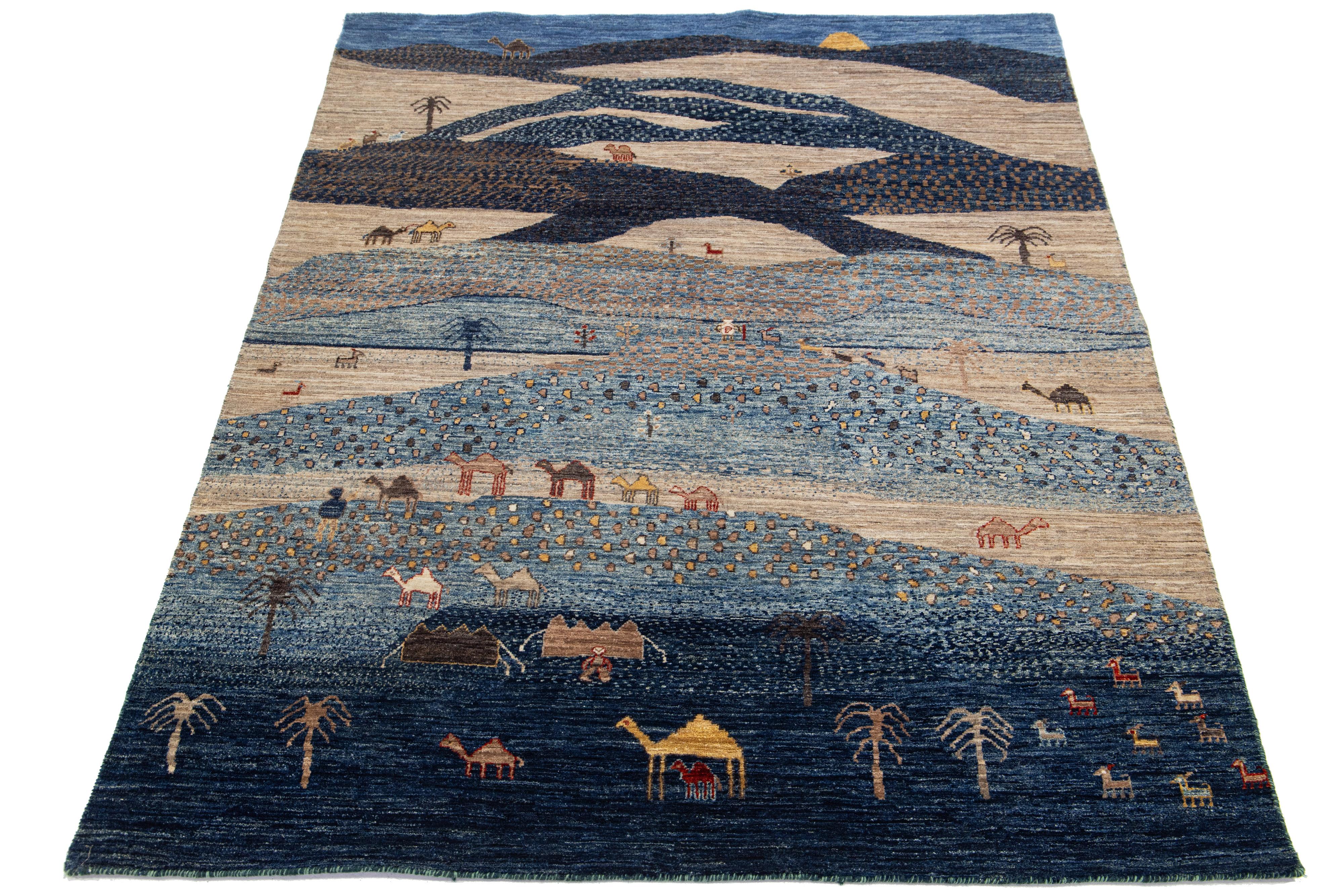 This handcrafted wool and silk rug, designed in the Gabbeh style, showcases a pictorial design accentuated by different shades against a vibrant blue background.

This rug measures 4'10