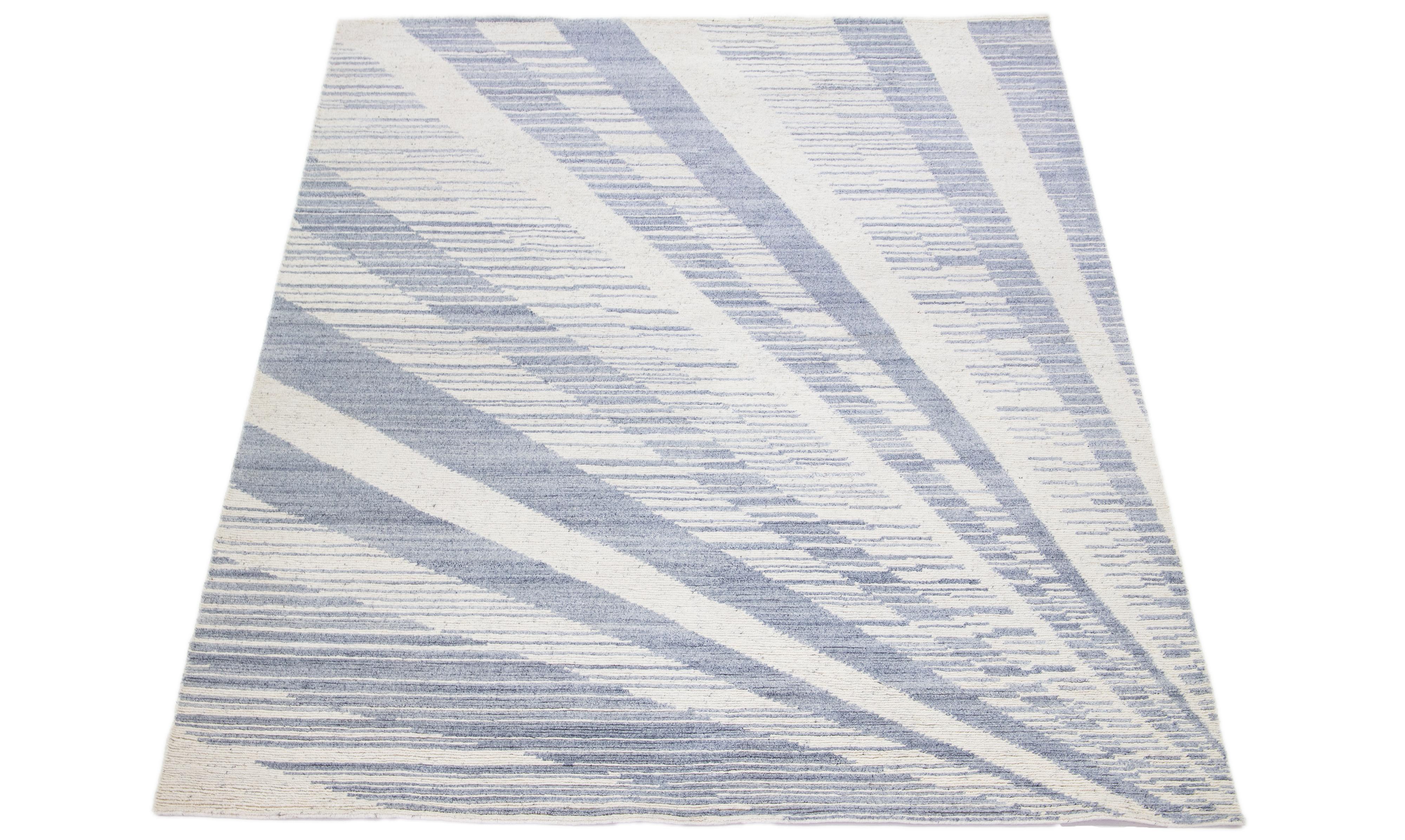 This modern wool rug showcases an abstract gray and ivory field with decorative ivory. The all-over design exemplifies the spirit of modernism in the 21st century, making it a truly sophisticated and fashionable addition to any interior