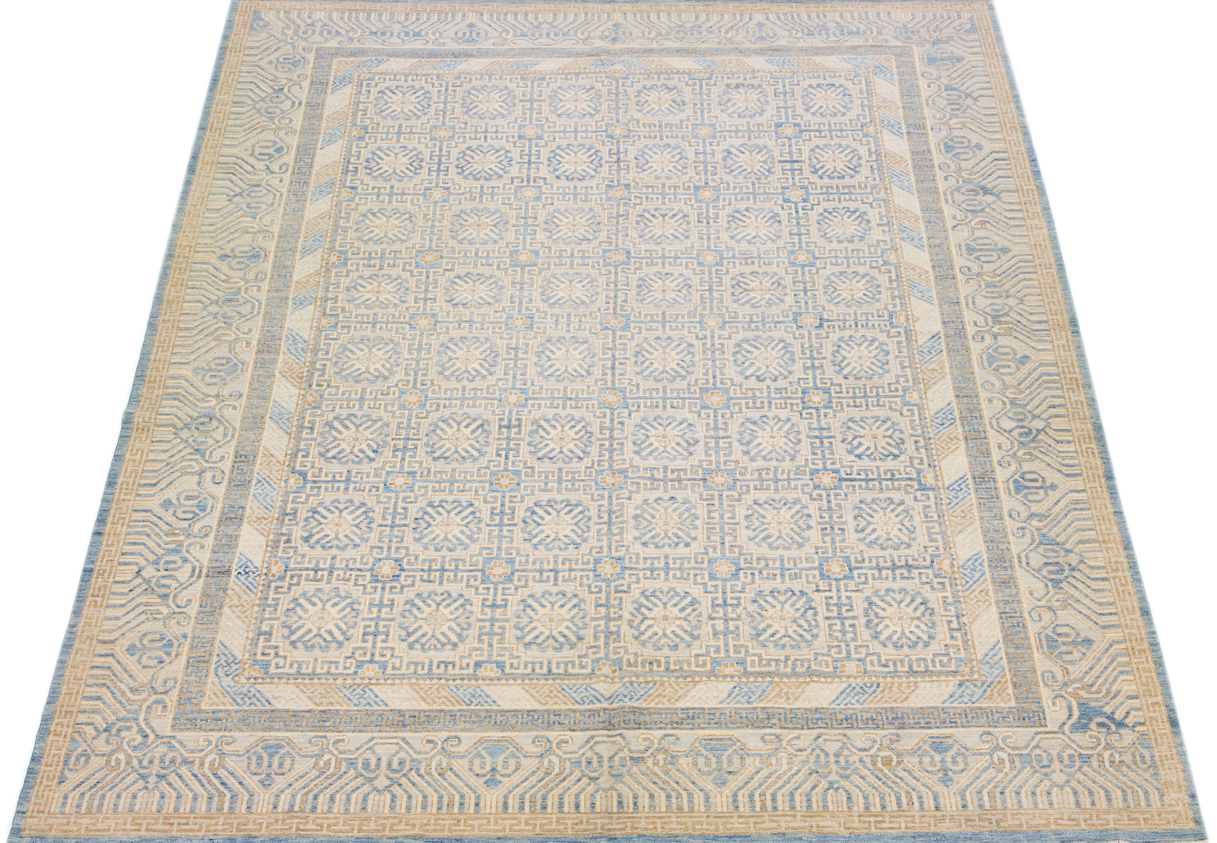 Schöner moderner Khotan Ton-in-Ton handgeknüpfter Wollteppich mit einem beigen Farbfeld. Dieses Stück hat blaue und braune Akzente in einem wunderschönen, miteinander verbundenen Medaillon-Rosettenmuster.

Dieser Teppich misst 12' x 15'4