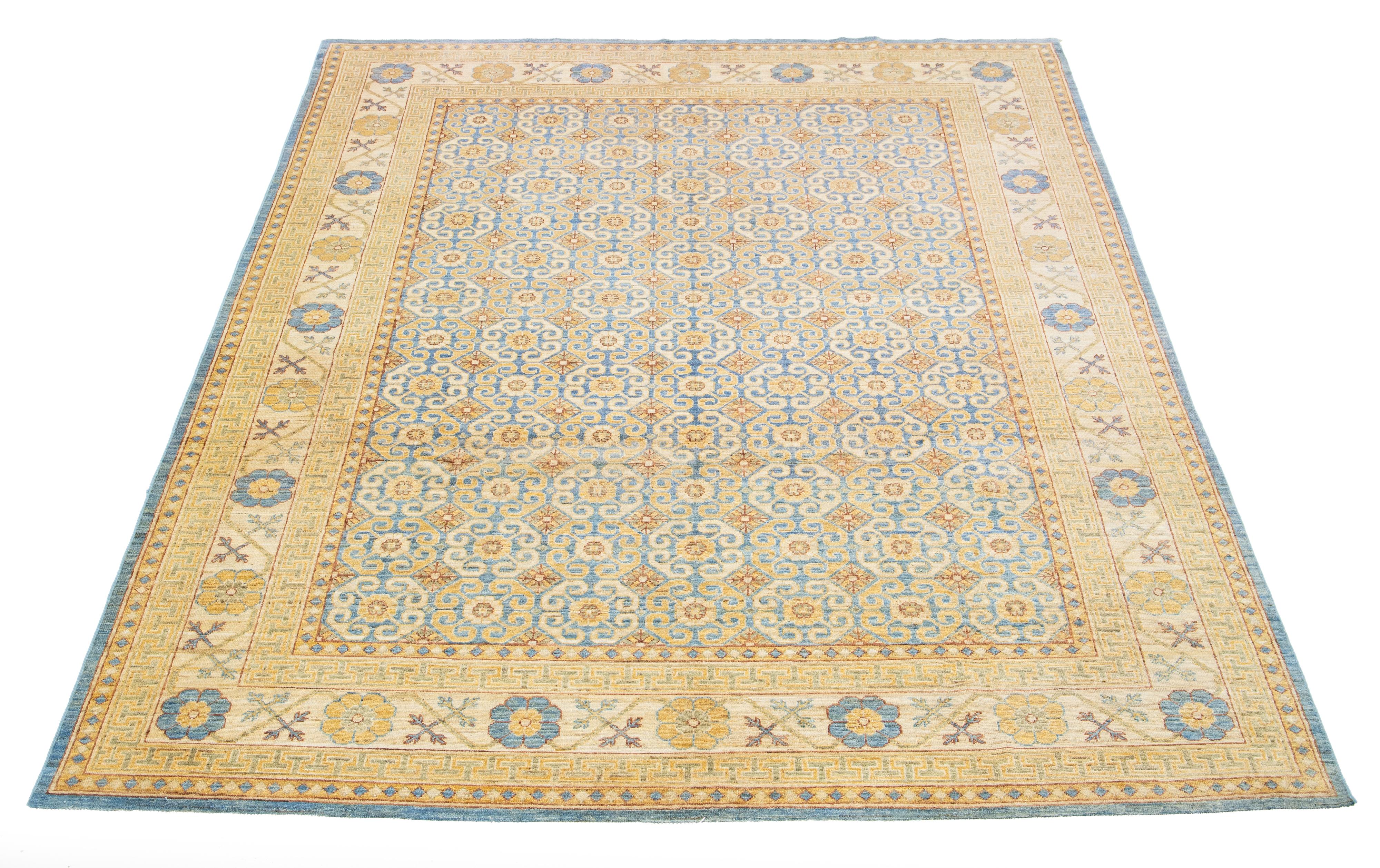 Il s'agit d'un magnifique tapis moderne en laine Khotan nouée à la main avec un champ beige. Son magnifique design présente des accents bleus et bruns. 

Ce tapis mesure 9' X 11'10''.

 Nos tapis sont nettoyés professionnellement avant d'être