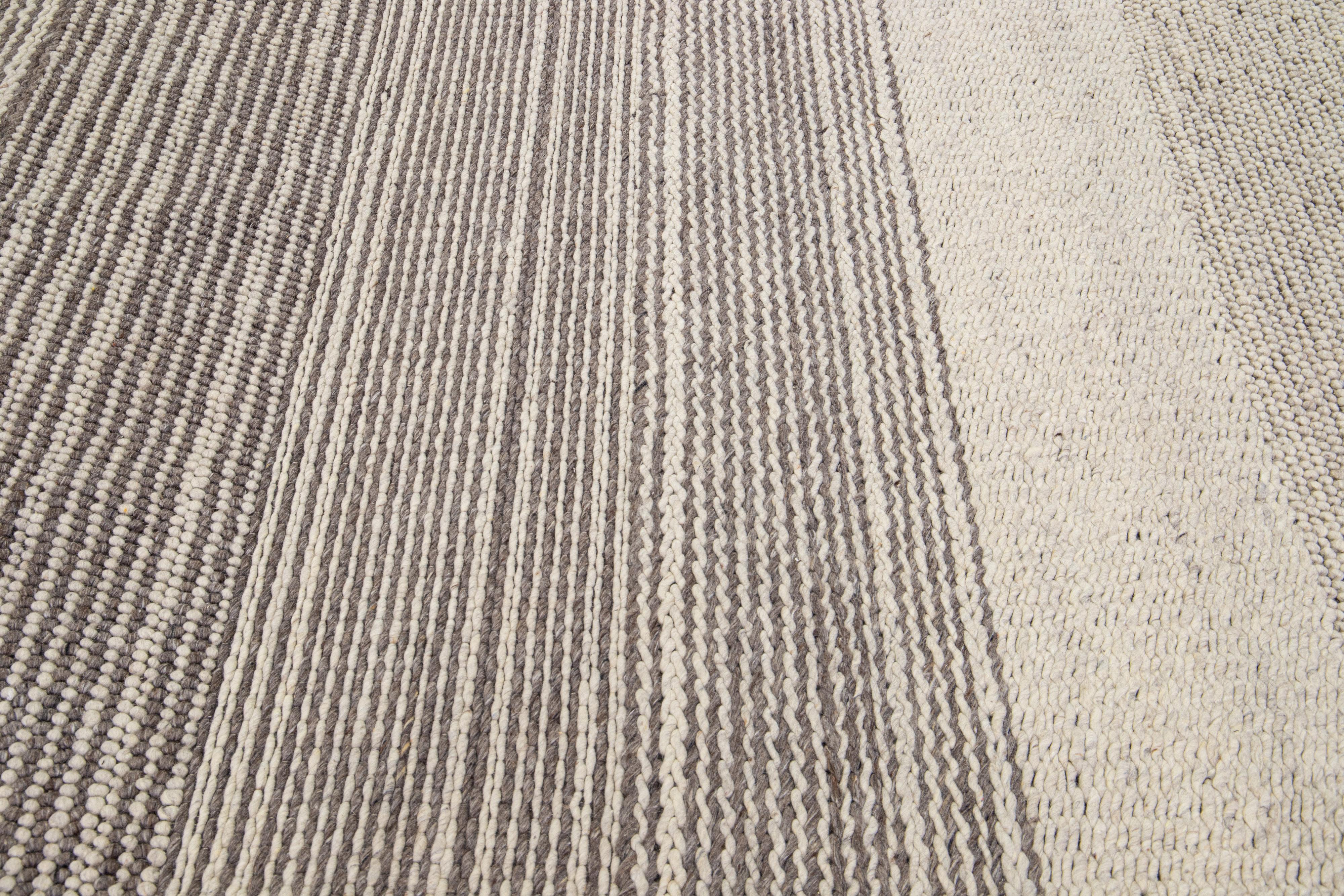 This hand-knotted wool rug boasts a modern Texture-style aesthetic, boasting a classic beige field with minimalist gray-colored stripes.

This rug measures: 8' x 10'.

Our rugs are professional cleaning before shipping.