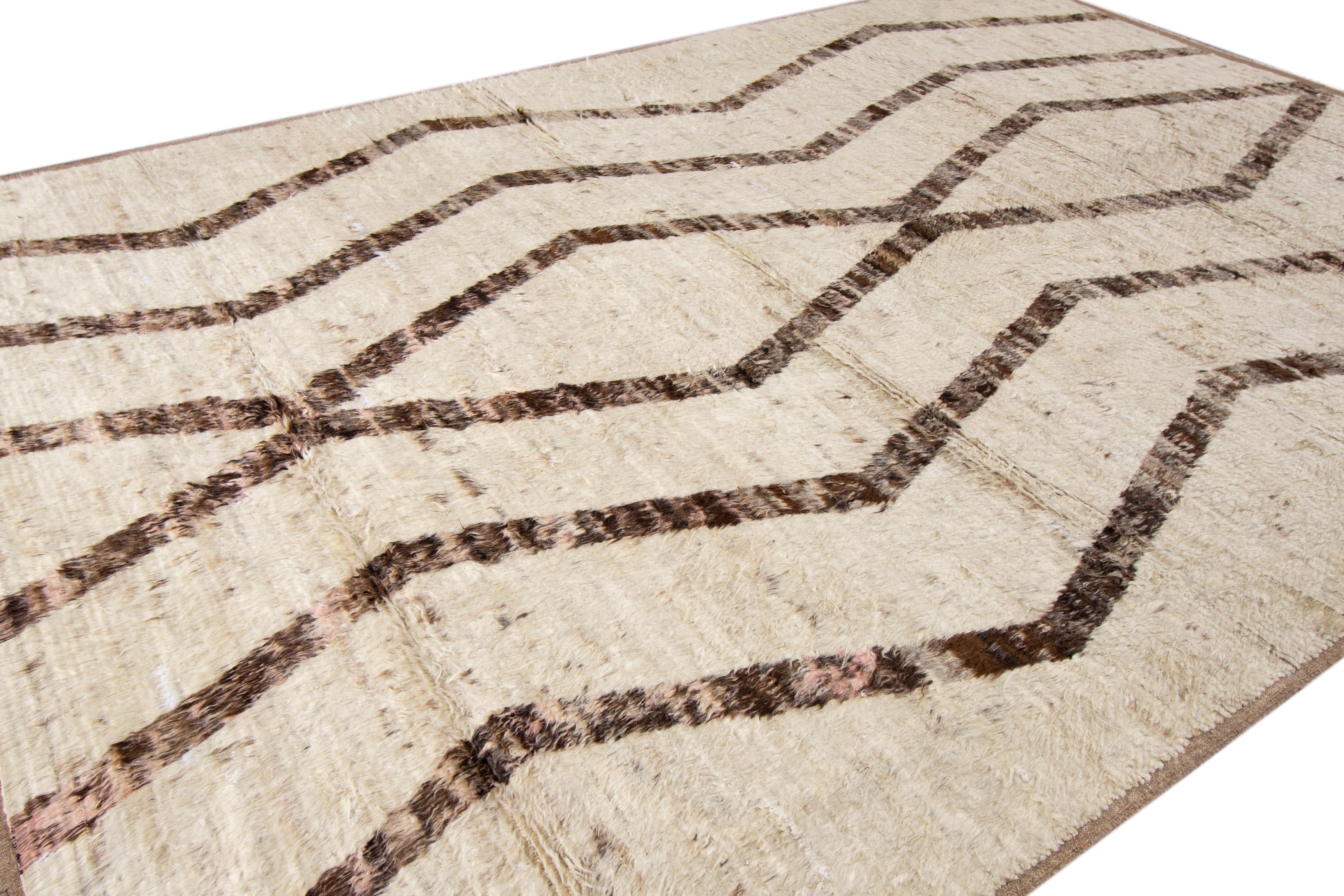 The mesmerizing Moroccan pattern showcased on this hand-knotted wool rug exudes a contemporary allure, blending an elegant brown hue with a captivating beige background. Its visually stunning Tribal design creates a captivating contrast, perfectly