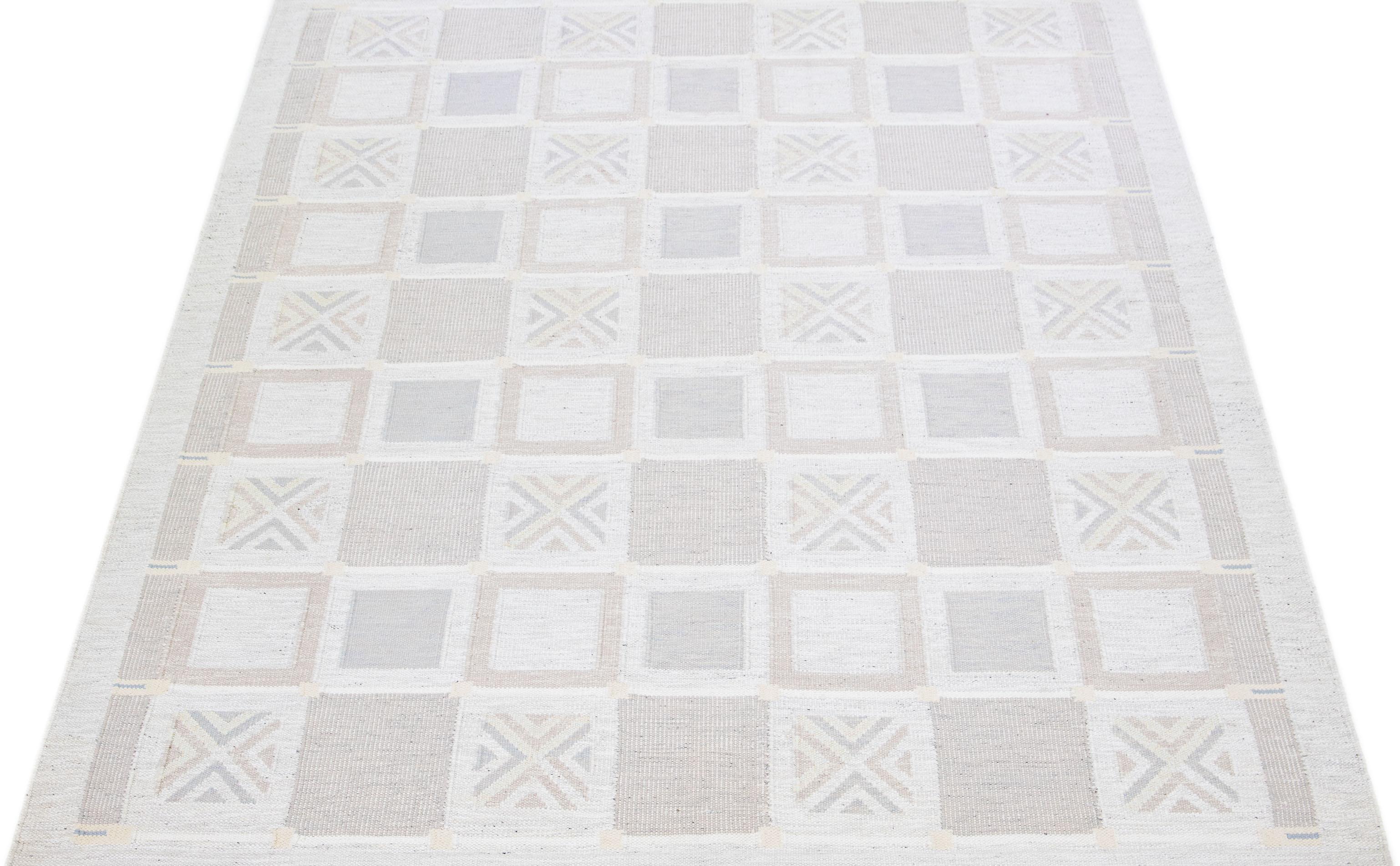 This flatweave rug boasts a contemporary Swedish style with a light gray base. Its stunning all-over geometric pattern is adorned with subdued accent hues that add a touch of elegance to any space.

 This rug measures 9' x 12'.

Our rugs are