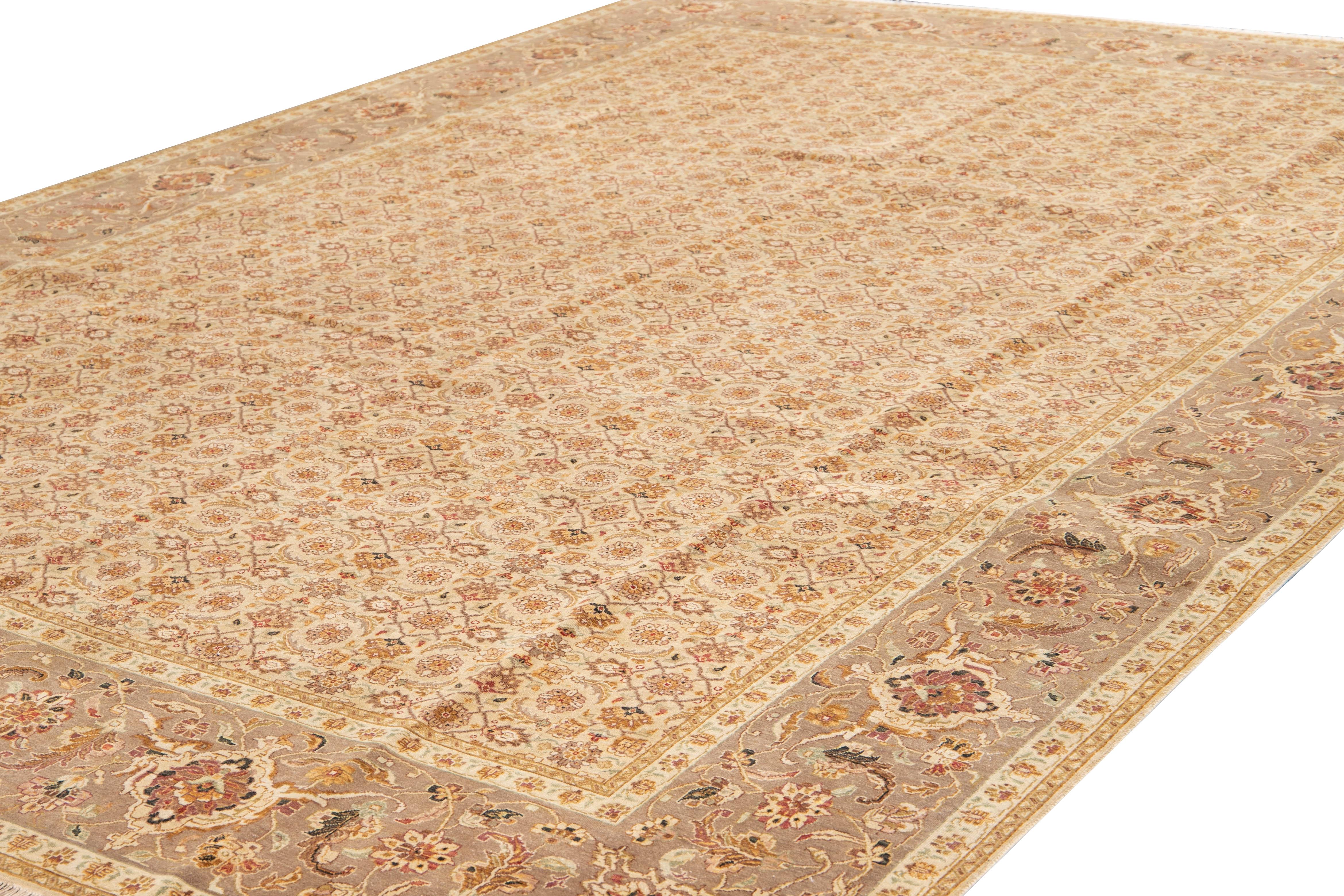 Beautiful antique Tabriz-style hand-knotted wool rug with a beige-cream color field. This piece has a red, brown, and green accent in a gorgeous floral design.

This rug measures 10'1