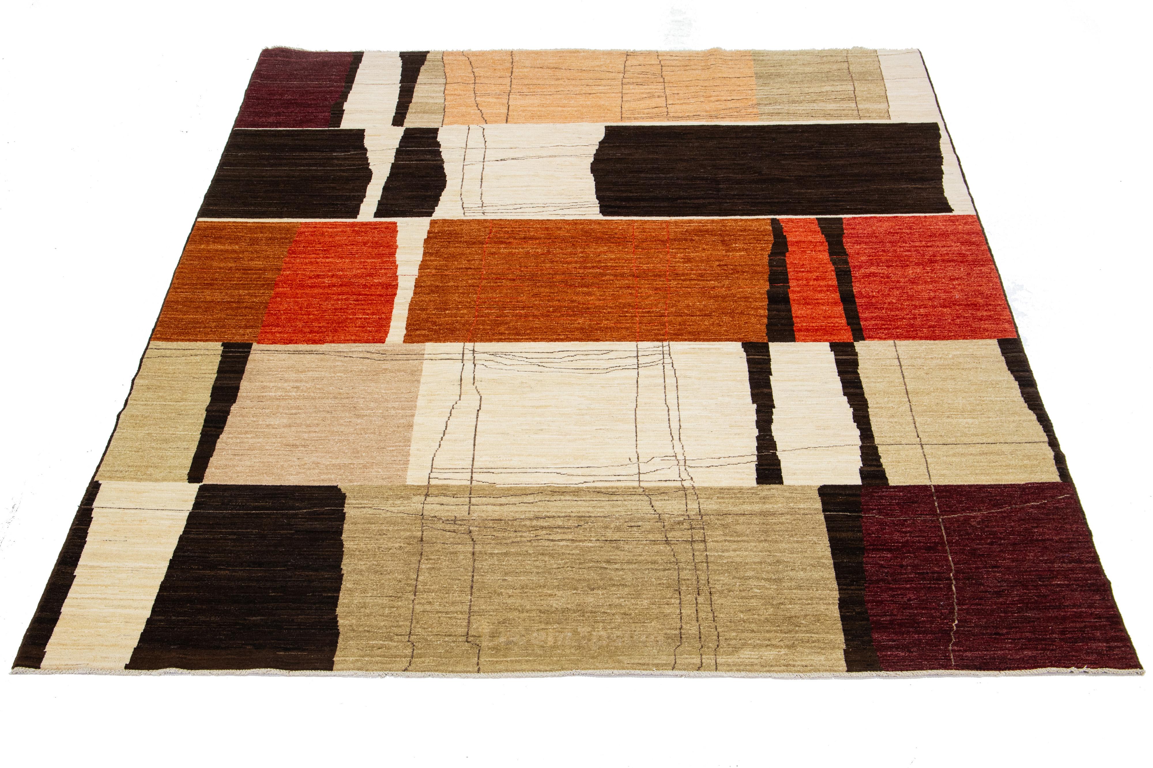 The beautiful modern hand-knotted wool rug features a multicolor color field of orange, brown, and beige. The rug also boasts a stunning textured abstract design.

This rug measures 9' x 12'.

Our rugs are professionally cleaned before shipping.
   