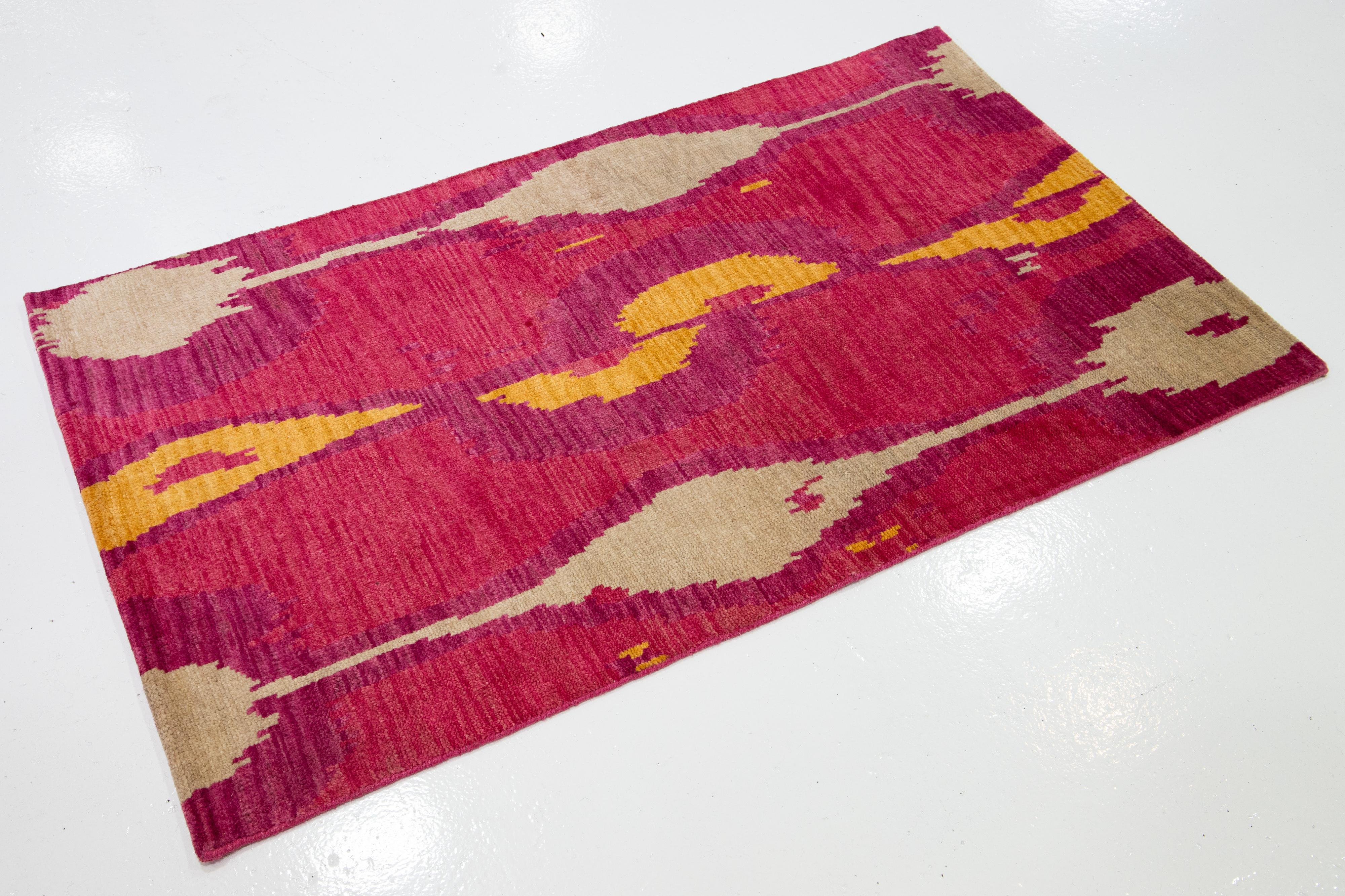 Ce tapis AMOMS moderne présente un aspect contemporain qui attire l'attention dans une pièce grâce à un motif surchargé dans des couleurs accrocheuses. Le mouvement est omniprésent dans cet étonnant motif de blanc et de jaune sur un champ rose