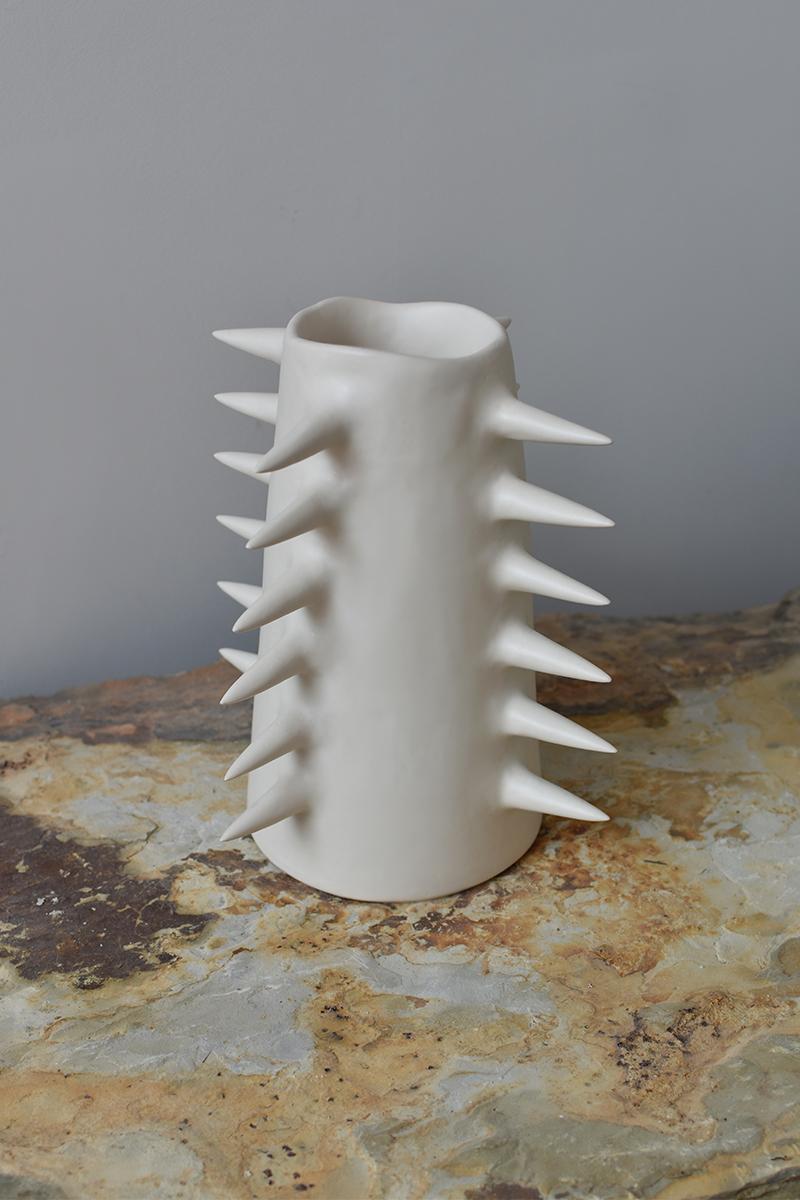 Beautiful white decorative vase with spikes, perfect for showcasing your cherished blooms. Providing a unique perspective from every angle, this handmade ceramic vase blurs the line between functionality and ornament. Use it either as a fully