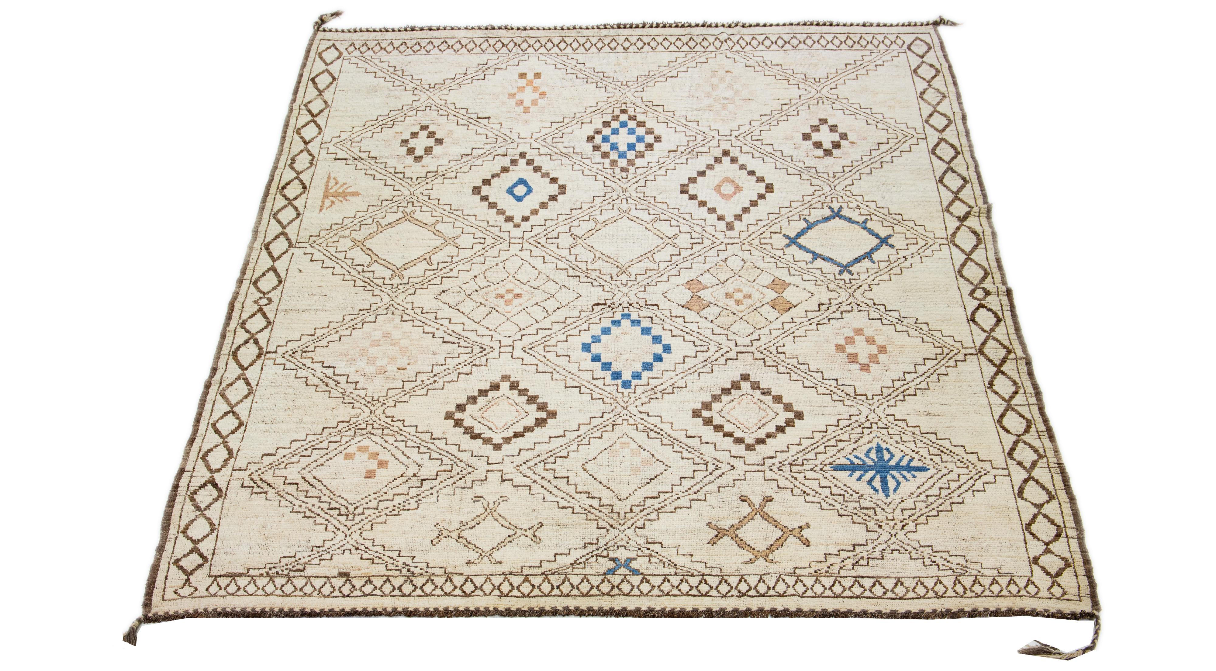 This oversize wool rug, expertly hand-knotted, showcases a fascinating Moroccan design. It exudes a contemporary appeal infused with a hint of retro styling, using an elegant mix of brown and blue colors against an entrancing beige background.

This