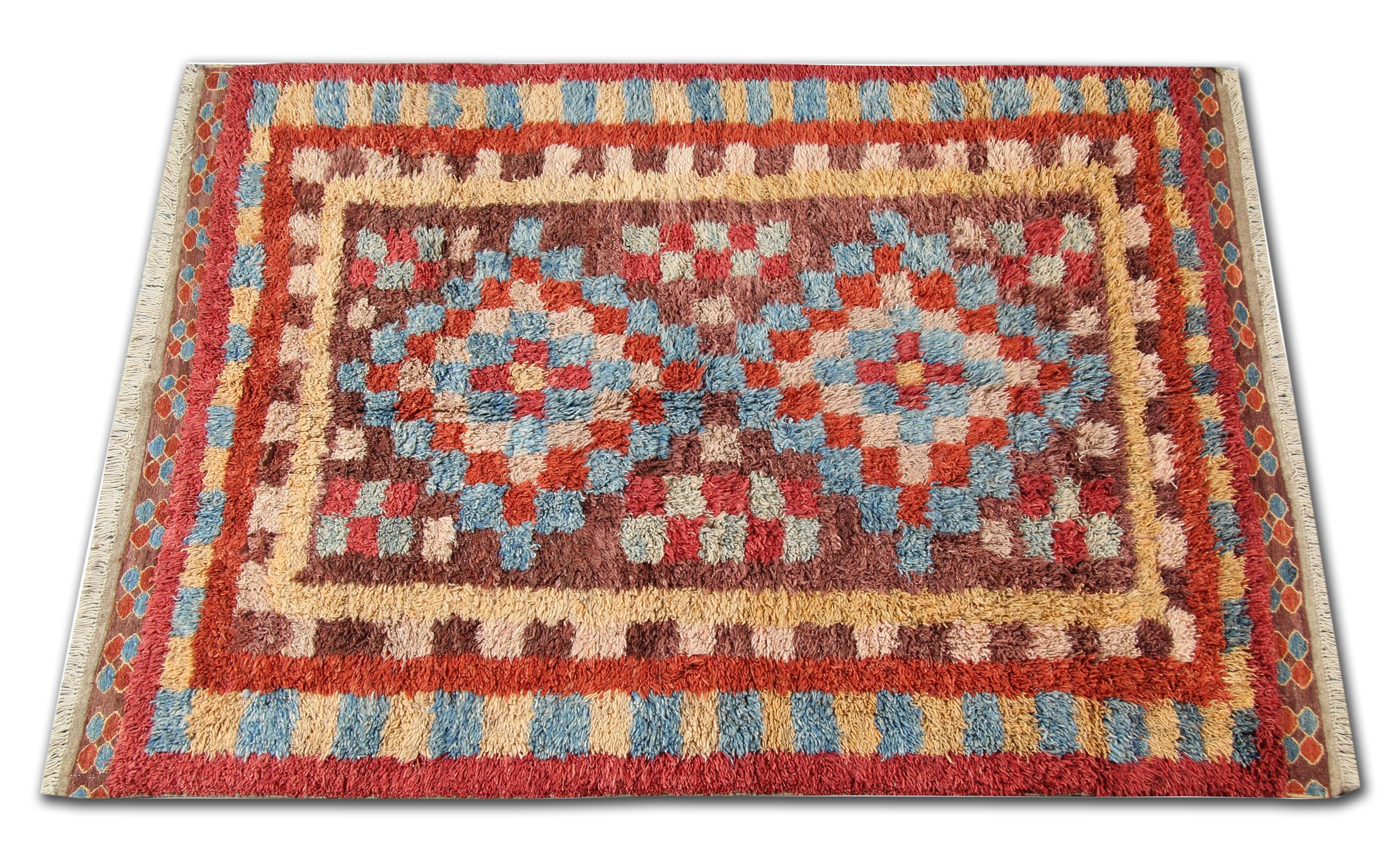 Dies ist ein Beispiel für einen handgewebten Teppich mit Motiven aus der Region Marokko. Marokko ist berühmt für seine primitiven traditionellen Teppiche mit langem Flor. Für die Herstellung dieses roten Teppichs verwendeten die Weber Wolle und