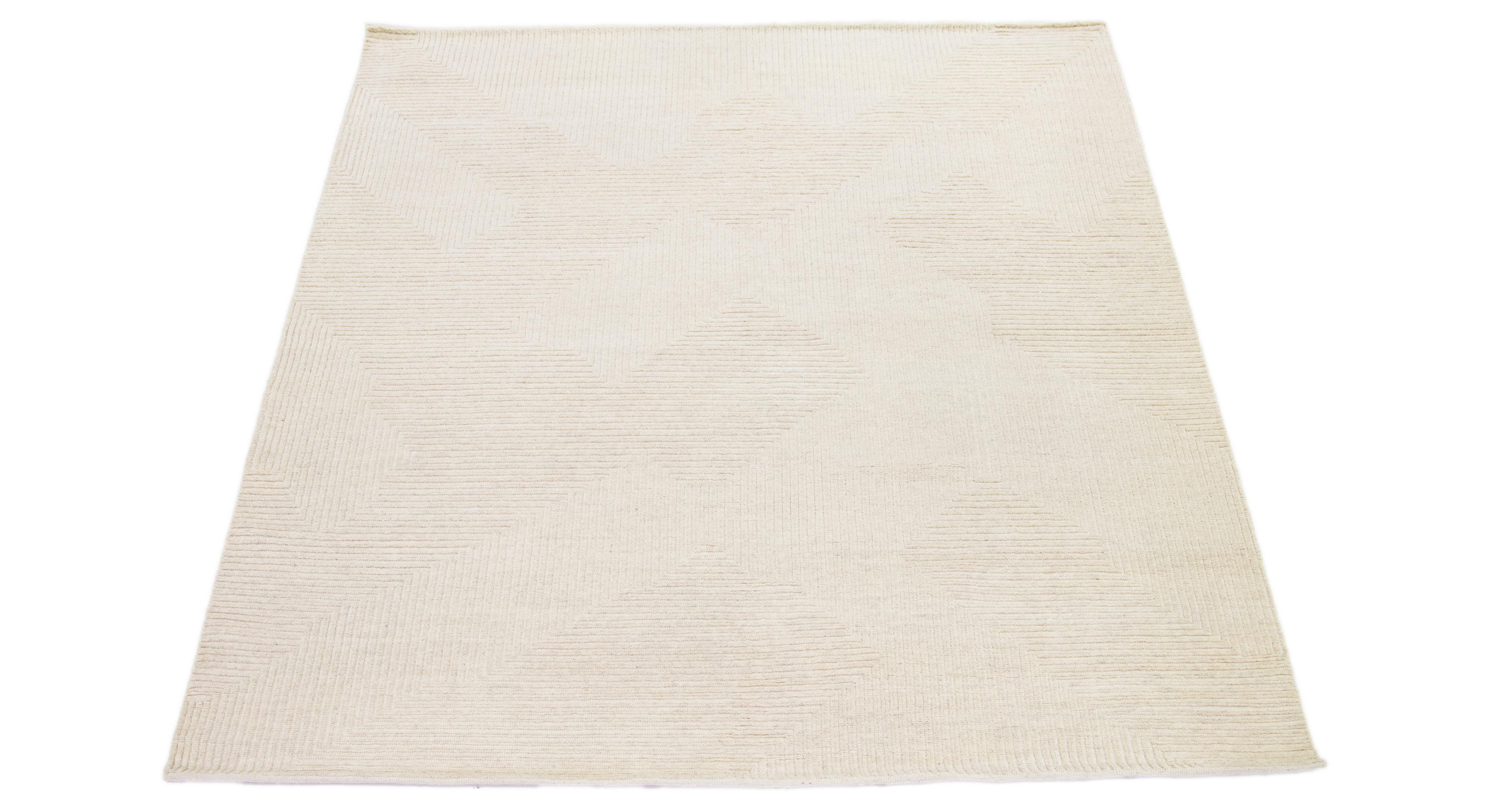 This hand-knotted wool rug showcases a modern Moroccan-inspired motif highlighting understated texture against a bold beige foundation, creating a captivating geometric Design.

This rug measures 8'2