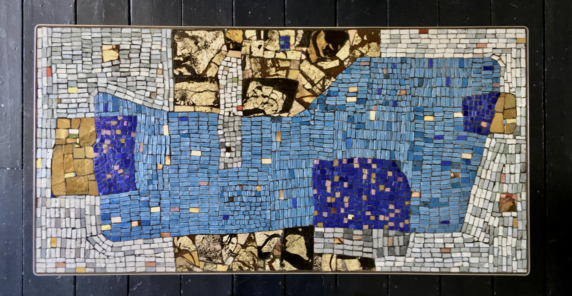 Handmade mosaic table by the German artist Helmut Lander (1924-2013). Signed and dated 1953.

A rare and beautiful piece, with rectangular top is decorated with irregular mosaic pieces, featuring shades of blue, off-white or pale grey, and earth