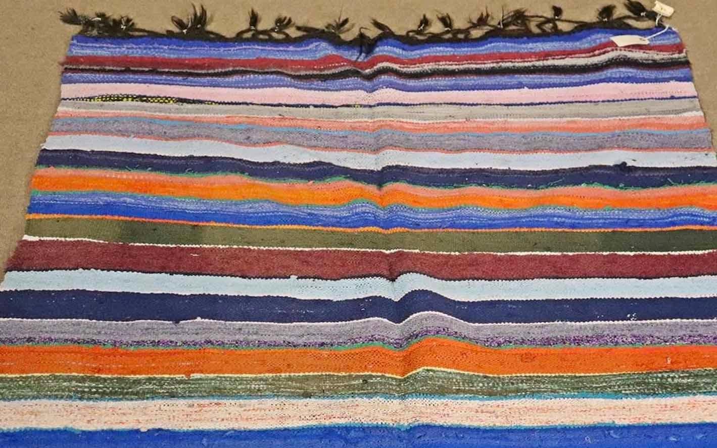 Handwoven multicolored rug measuring over 8 feet long.
Please confirm location.