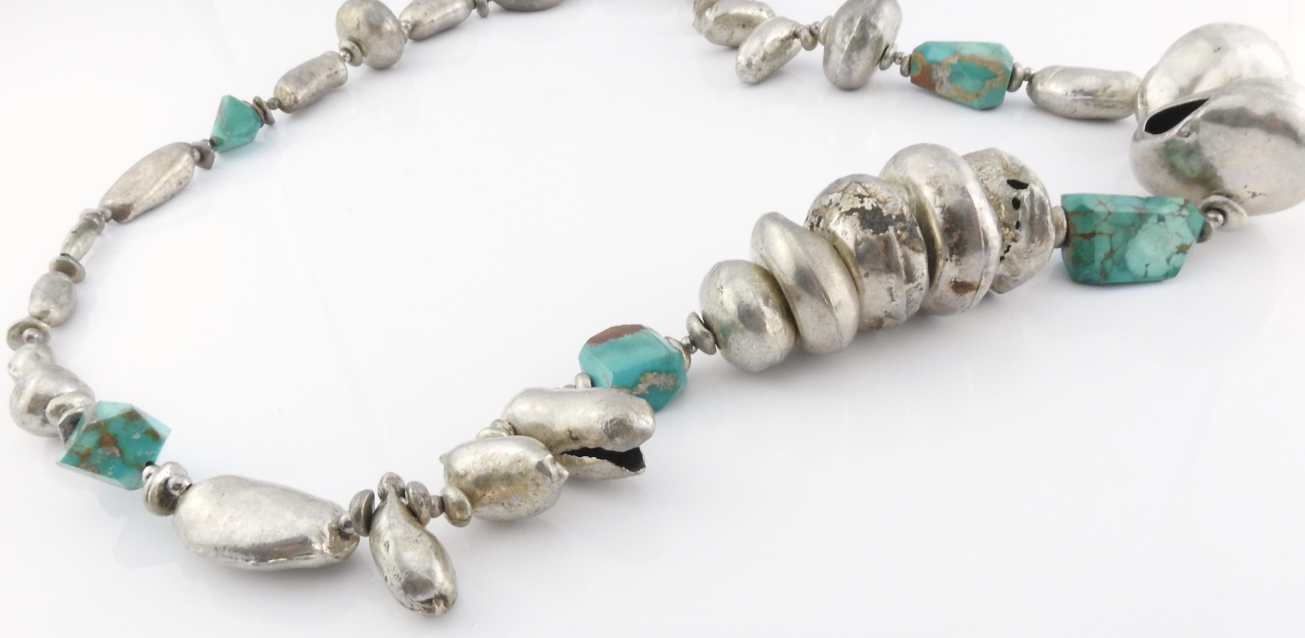 Vintage handmade puffy hollow silver bead and turquoise chunk necklace.

Weighs 260.7g, 167.6dwt.

Necklace has no markings.

Has not been polished.

Beads range in size from 5mm x 12mm to 39mm x 25mm.

Turquoise chunks range from 12mm x 14mm to