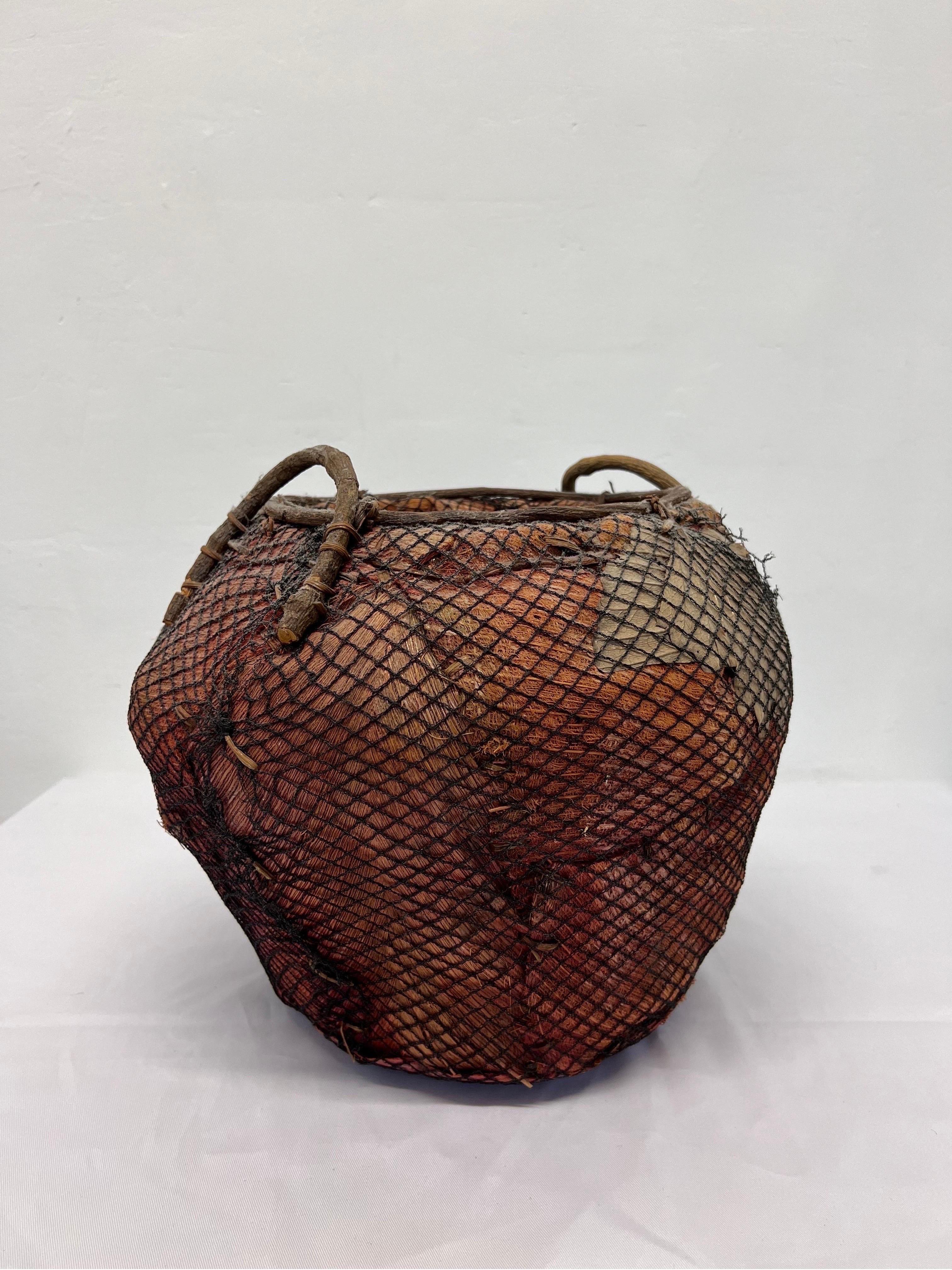 Philippine Handmade Natural Fiber and Leaf Basket Wrapped in Fish Net, 1970s For Sale