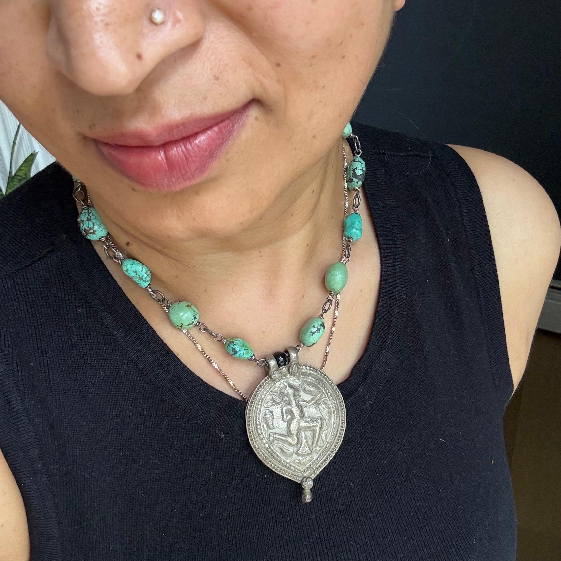 A powerful and meaningful statement necklace, handcrafted by the artist using rare and spiritually rich materials. At its center is an antique silver amulet pendant from India, featuring a stamped image of Hanuman, the revered Hindu deity known for