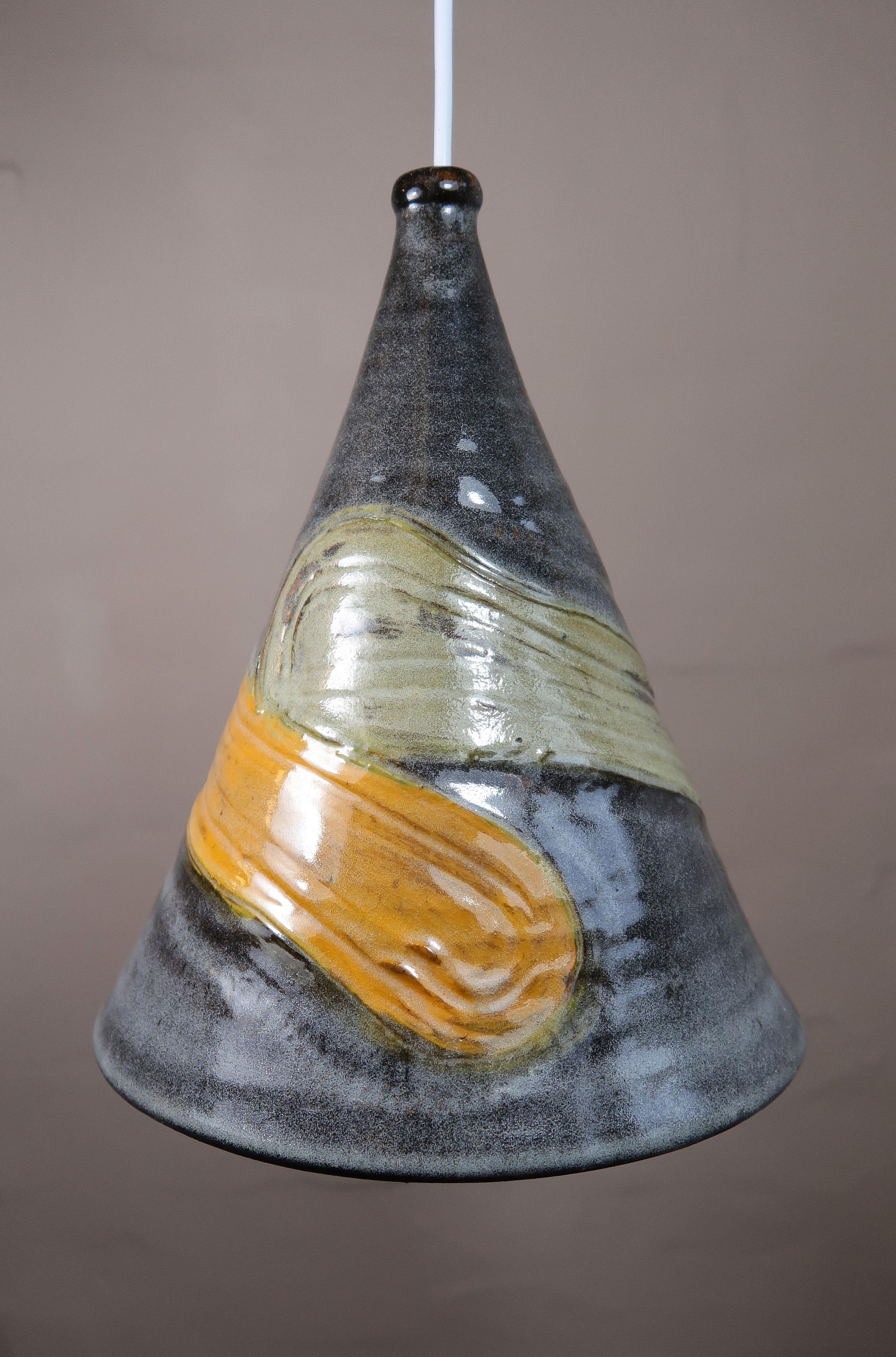 One of a kind Scandinavian Mid-Century Modern ceramic pendant designed and handmade by Marianne May - a student of Bjørn Wiinblad. Handmade organic relief pattern swirling around the center of the cone shaped ceiling lamp. Warm grey with yellow