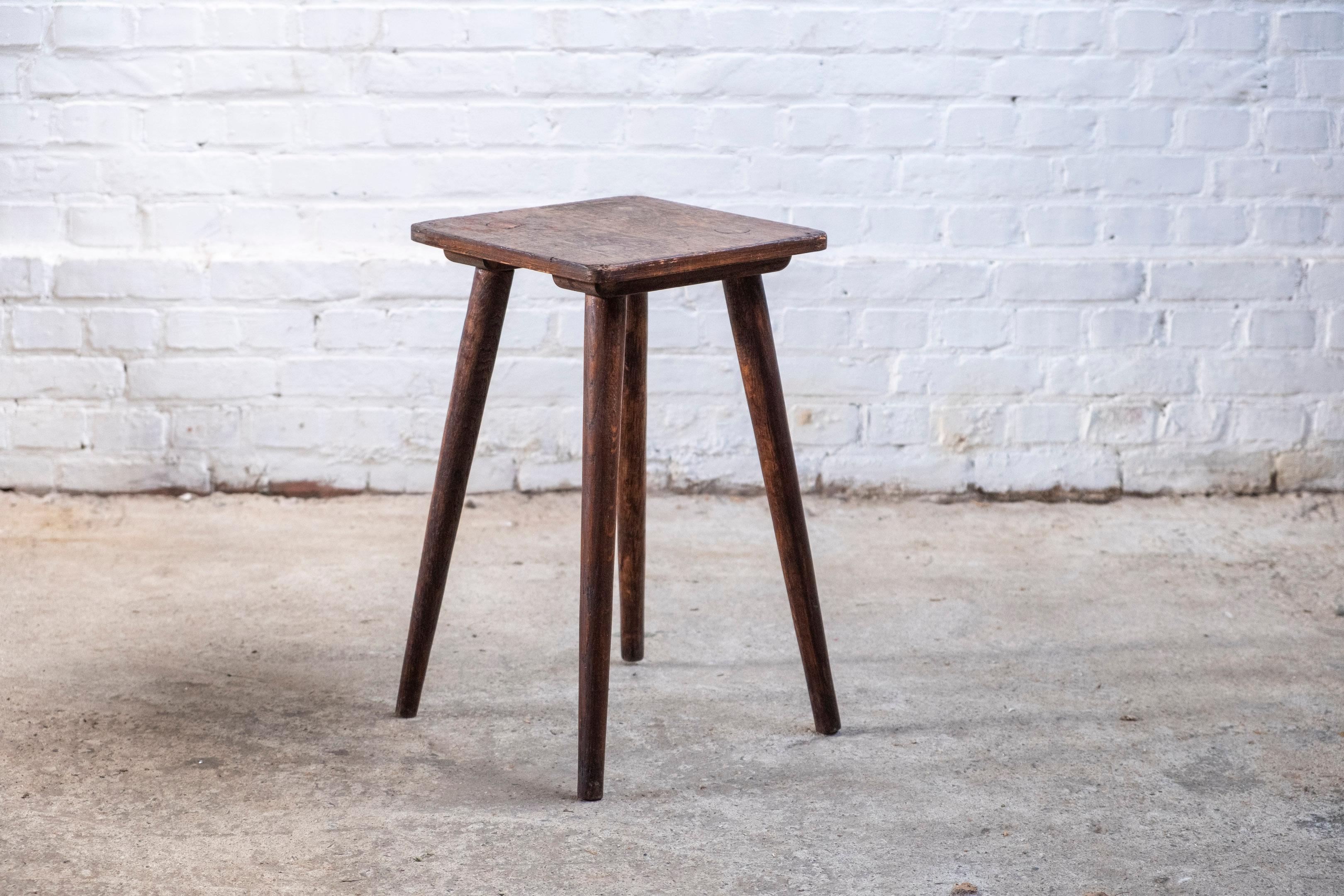 Ce tabouret artisanal de belle facture, fabriqué en Belgique dans les années 1950, est un bel exemple de meuble minimaliste et fonctionnel. Fabriqué en chêne teinté foncé, il présente des lignes simples et épurées qui mettent en valeur la beauté
