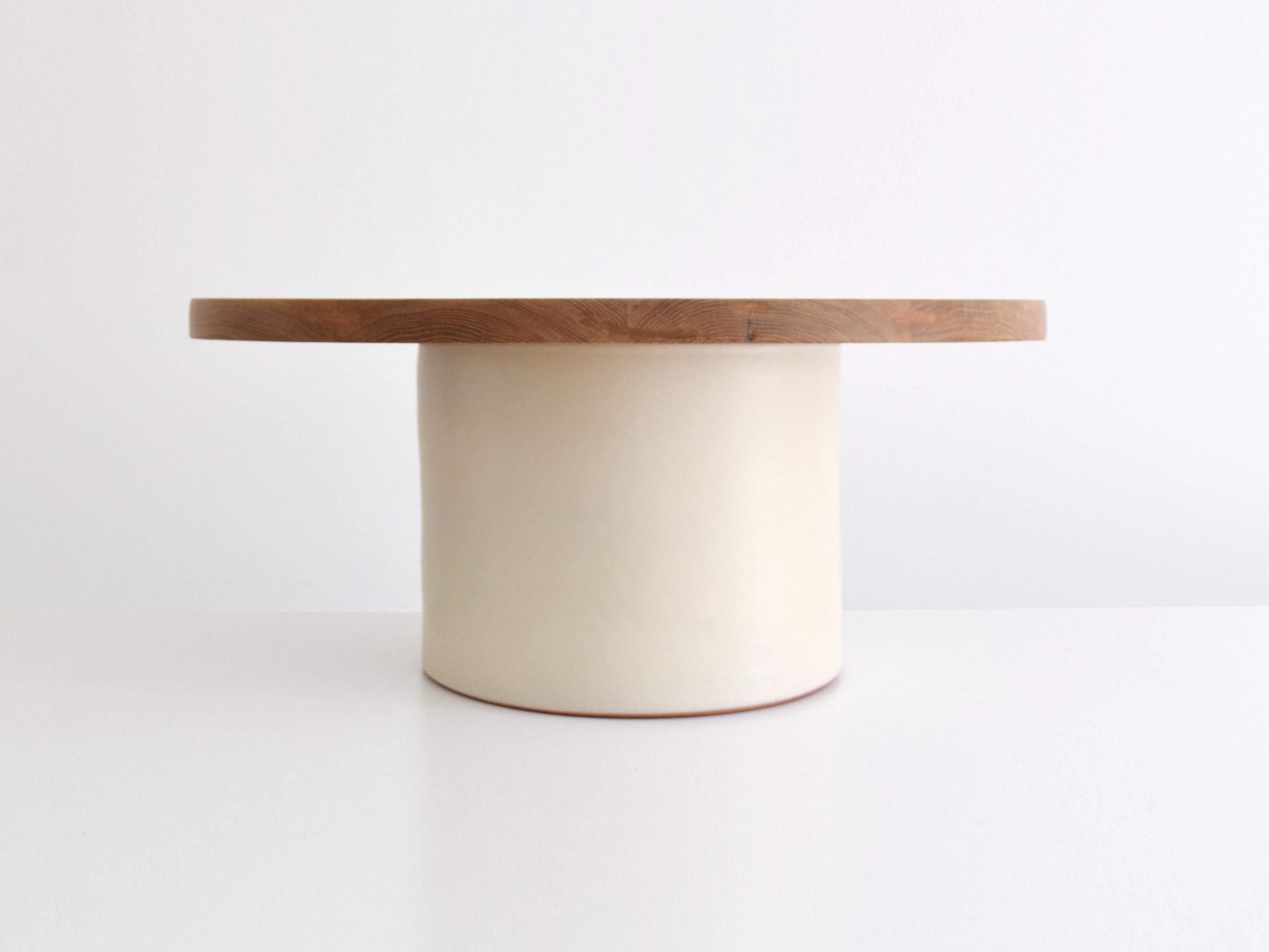 This coffee table pairs a bold ceramic pedestal base with a solid oak top, offering both presence and functionality. The 80 cm round wood top provides ample space while adding natural warmth and contrast to the design. A statement piece for living