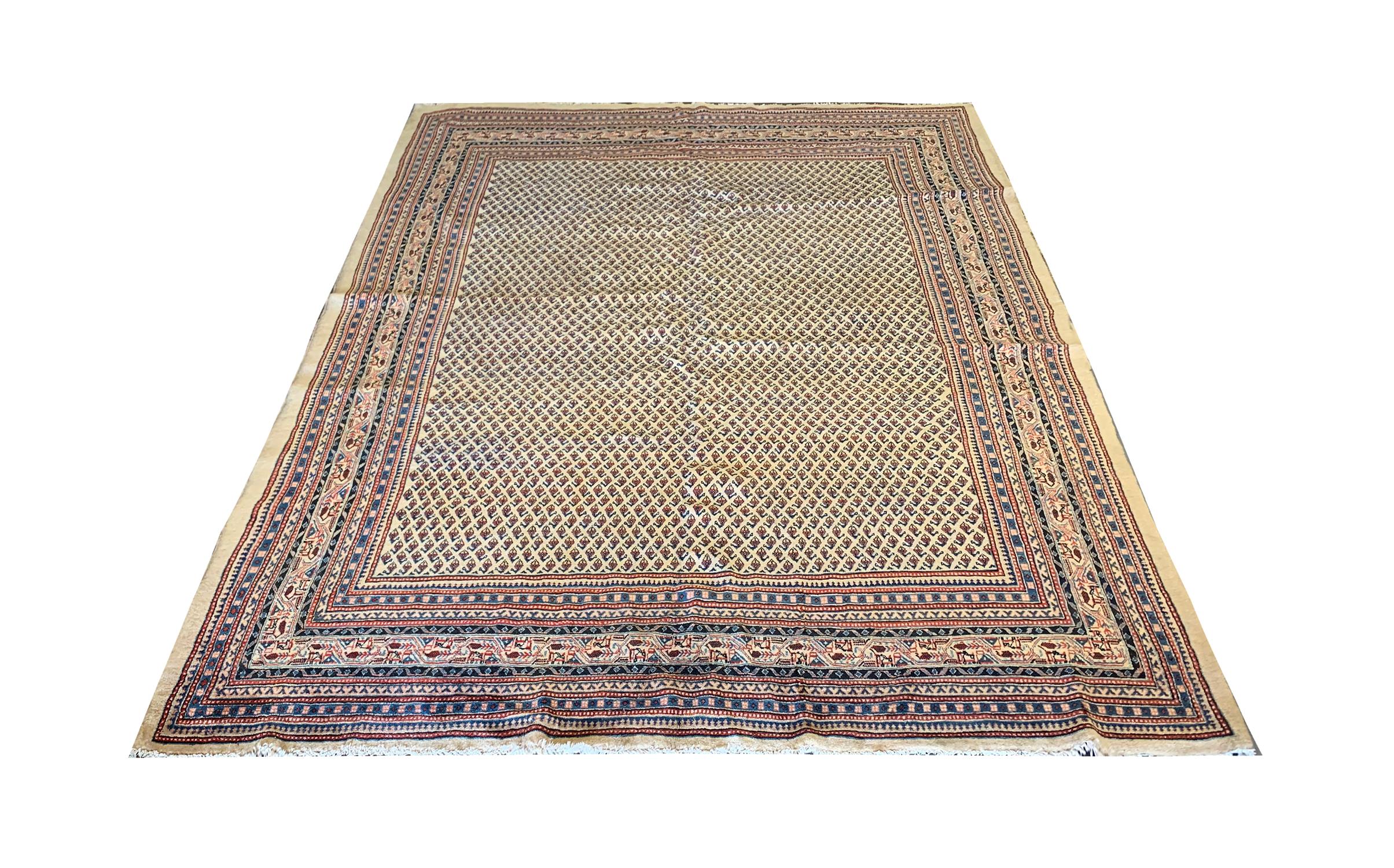 Delicately woven by hand, this traditional area rug was constructed in the 1900s. Featuring a repeating pattern central design and decorative layered border. Woven with a sleek colour palette with a cream background and blue, black and red accents