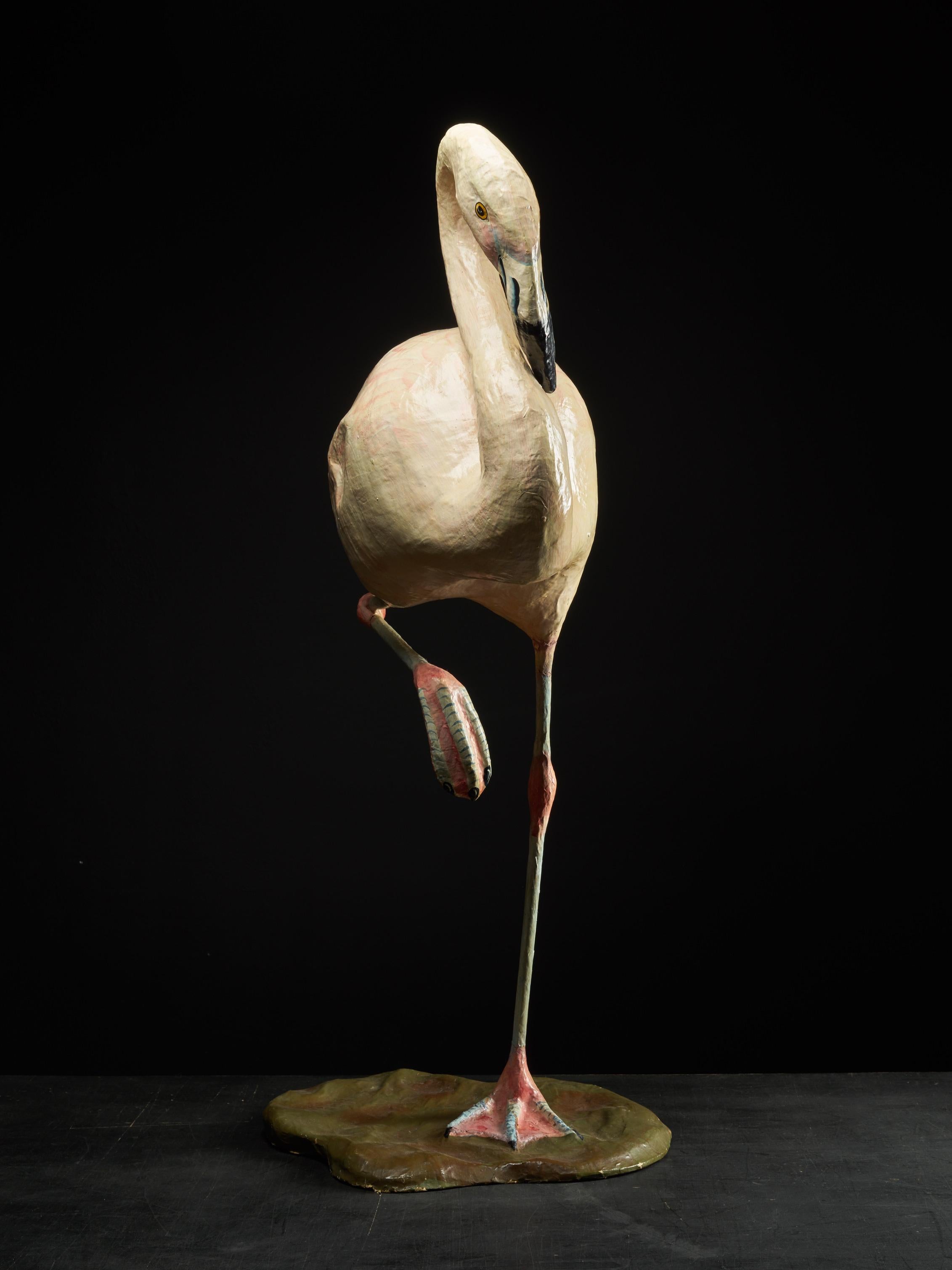 This handmade papier mâché flamingo has its original colors. It's about one meter high and stands on one leg. The flamingo dates from the mid-20th century.
