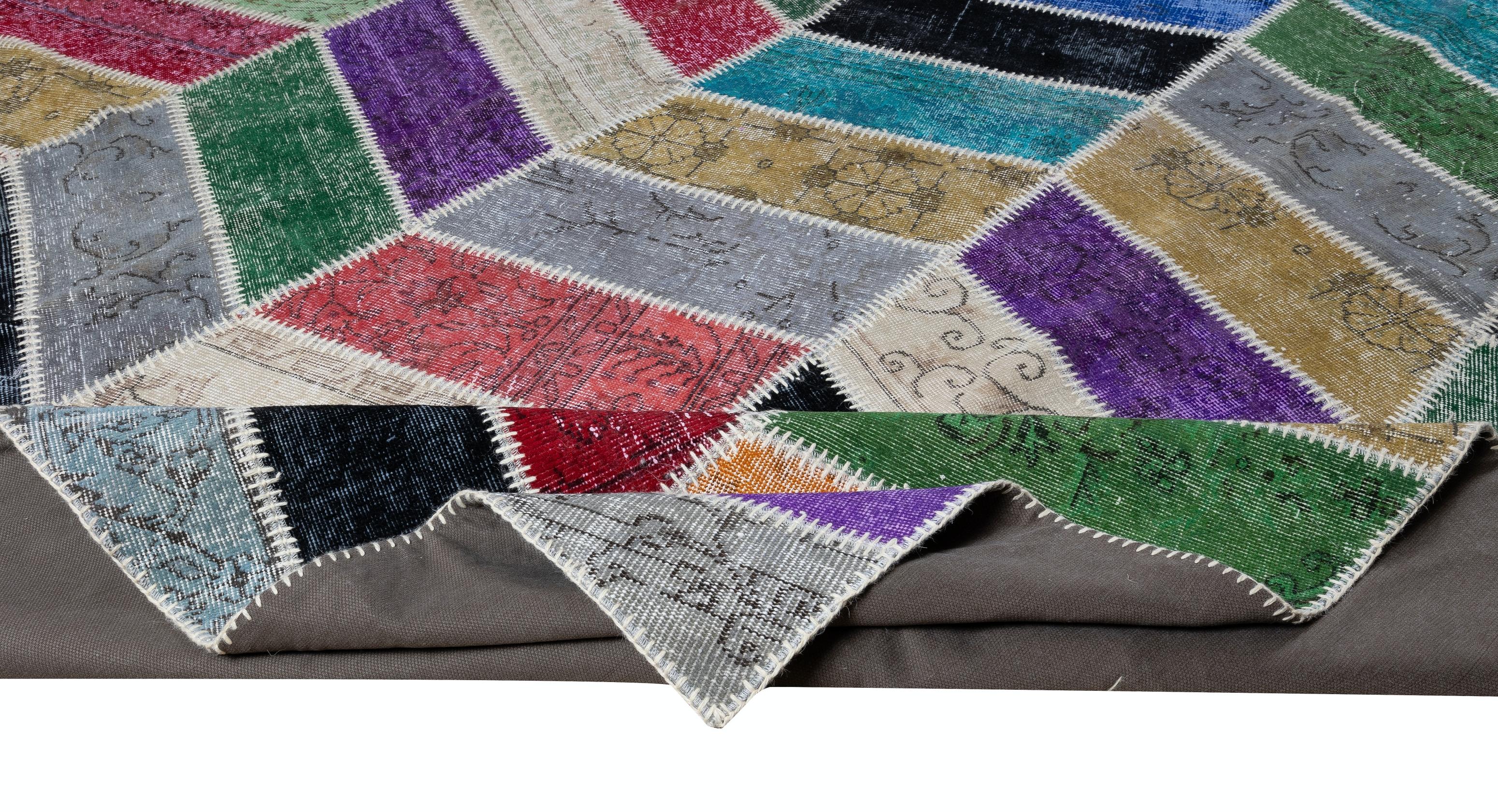 Assorted pieces of vintage hand-knotted Turkish carpets were washed, sheared, re-dyed in various colors, cut into geometric shapes then stitched together by hand to create this beautiful one of a kind patchwork rug. 
A durable dark color cotton
