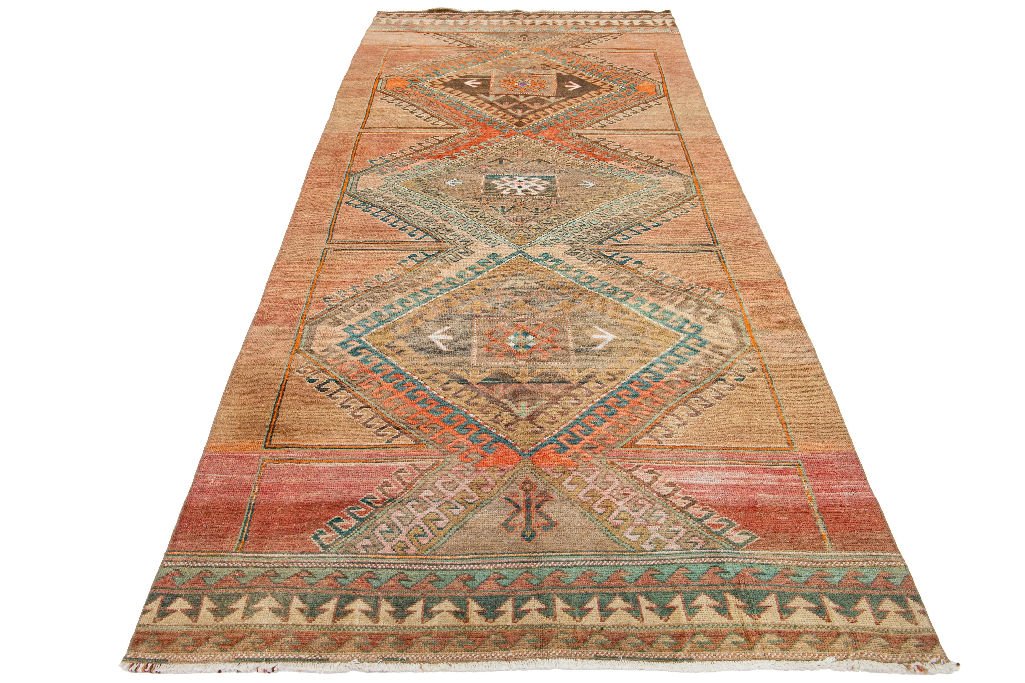Dieser schöne alte türkische Kars-Teppich aus handgeknüpfter Wolle hat ein pfirsichfarbenes Feld. Es zeigt ein atemberaubendes Tribal-Muster mit blauen, orangen, braunen und grünen Akzenten.

Dieser Teppich misst 4'10