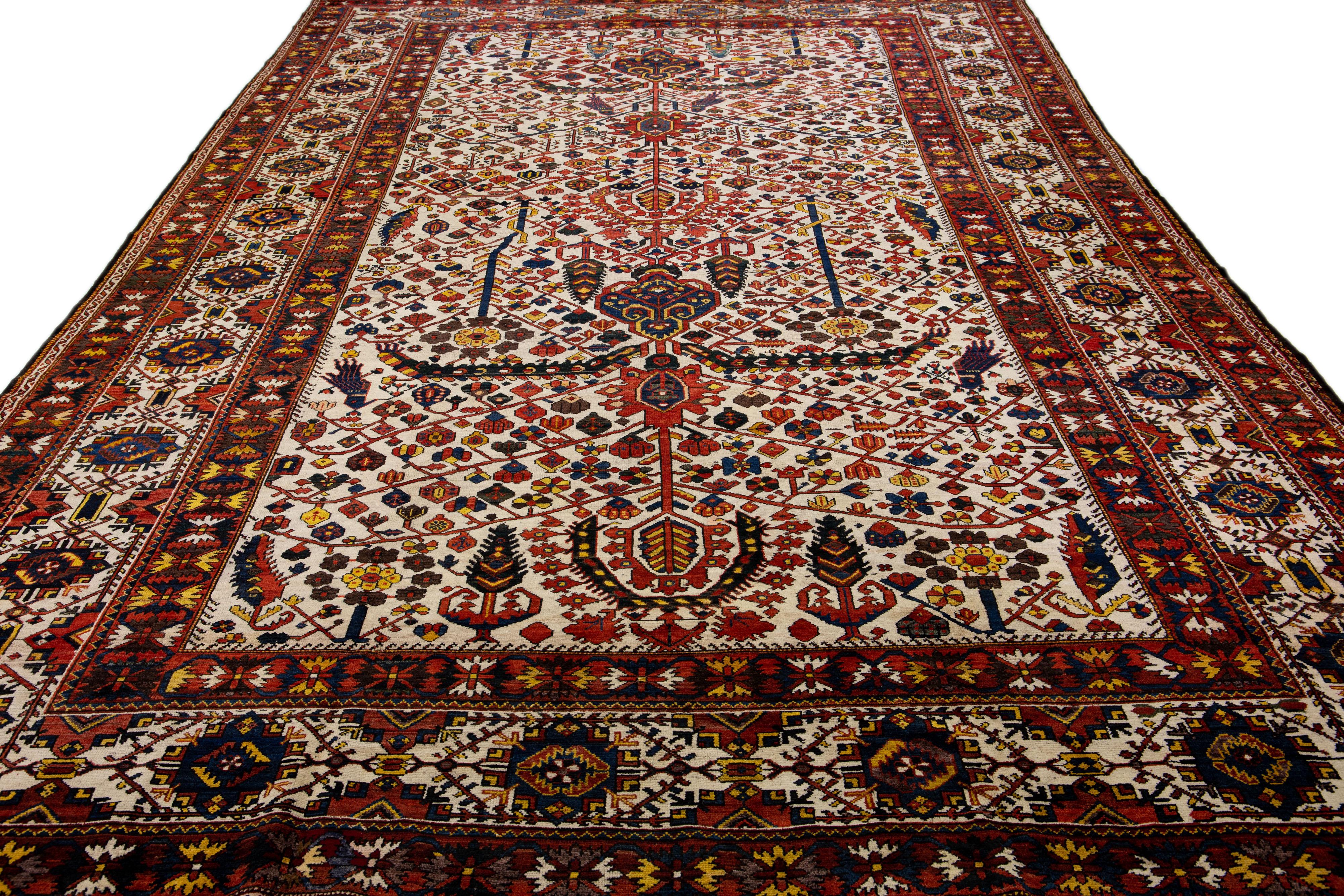 Schöner antiker, handgeknüpfter Bachtiari-Wollteppich mit beigem Farbfeld. Dieses persische Stück hat einen All-Over-Multicolor-Akzent in einem prächtigen traditionellen Motiv.

Dieser Teppich misst 13' x 21'.
 
