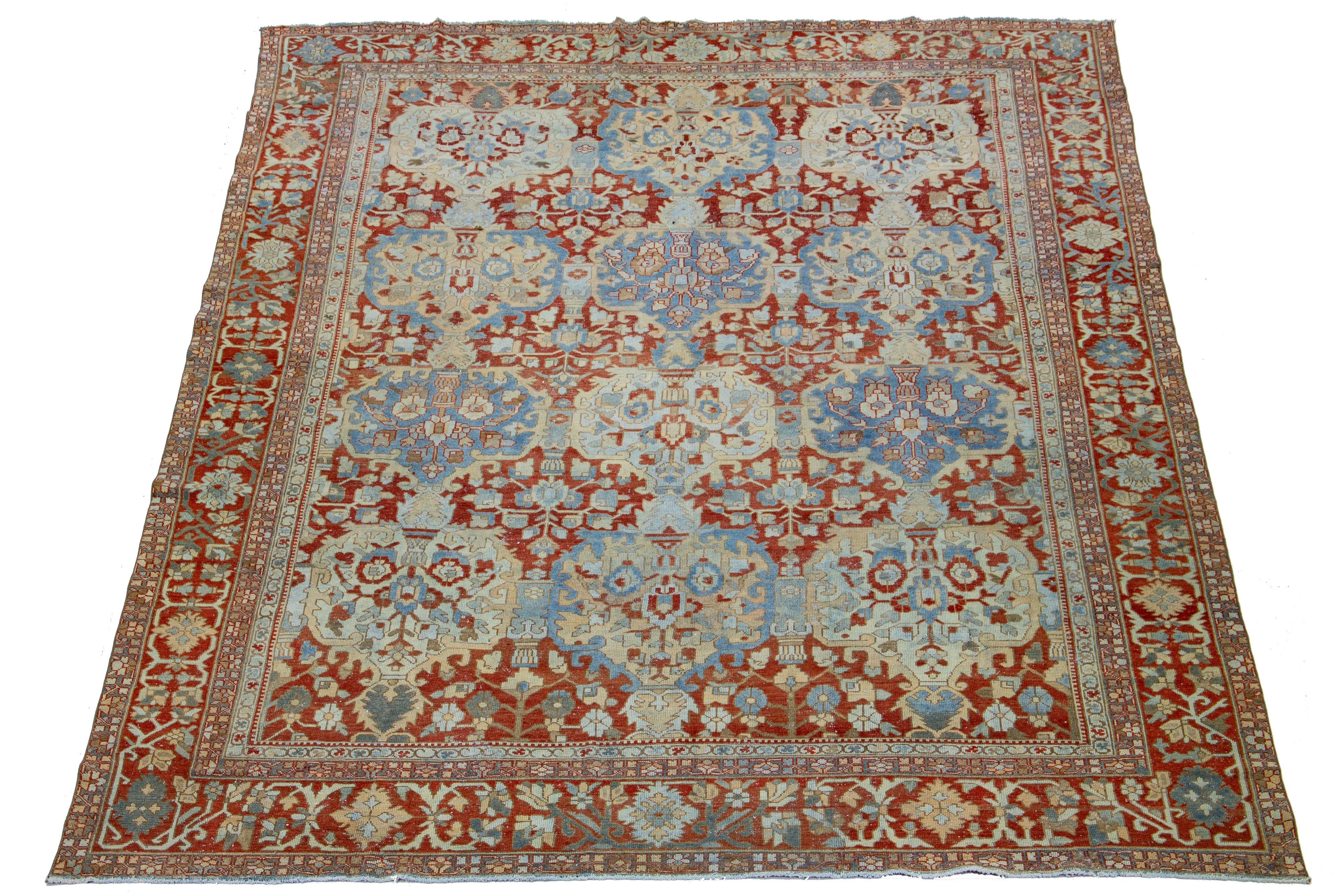 Beautiful Antique Bakhtiari hand-knotted wool rug with a red-rust color field. This Persian piece has blue and peach hues on a classic floral pattern.

This rug measures 12'5