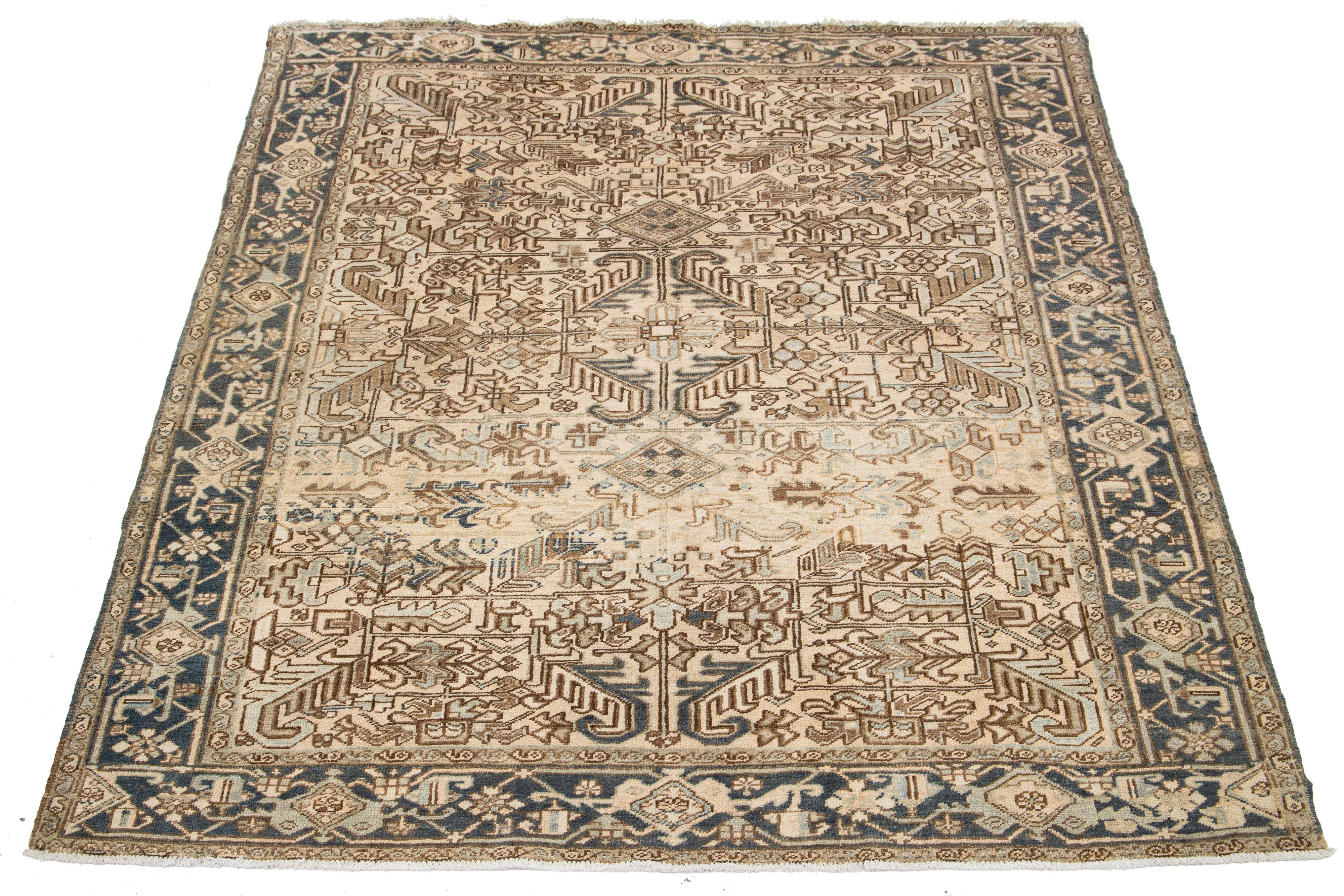 An antique Persian Heriz hand-knotted wool rug features a blue and brown all-over pattern on a beige field.

This rug measures 7'6' x 9'2