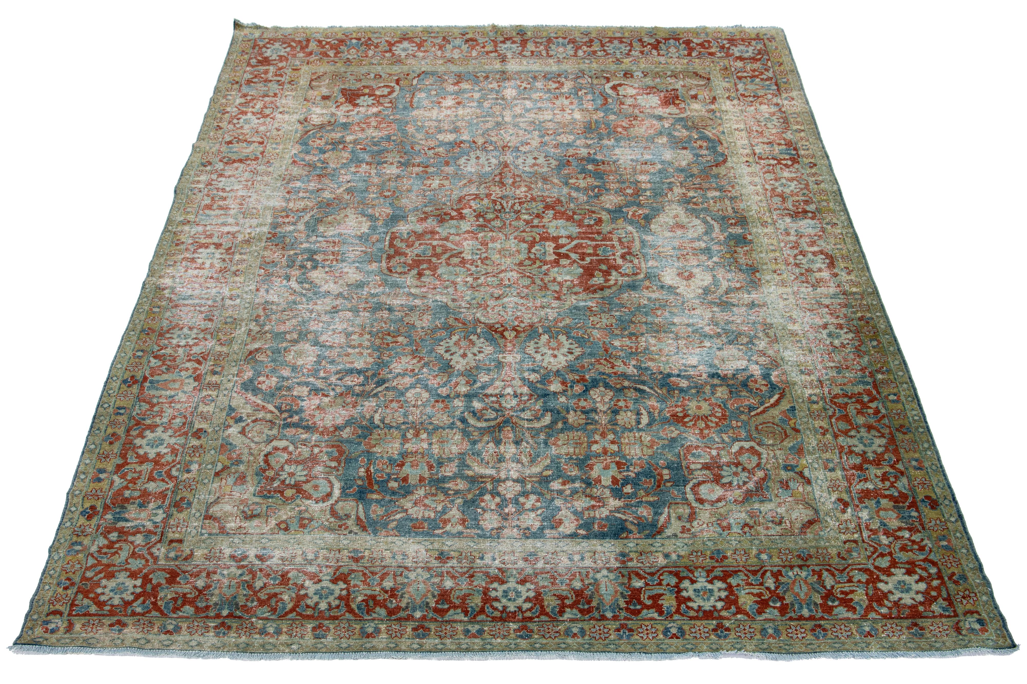 A hand-knotted wool antique Mahal distressed rug has a medallion design with red accents on a blue background.


This rug measures 8'2