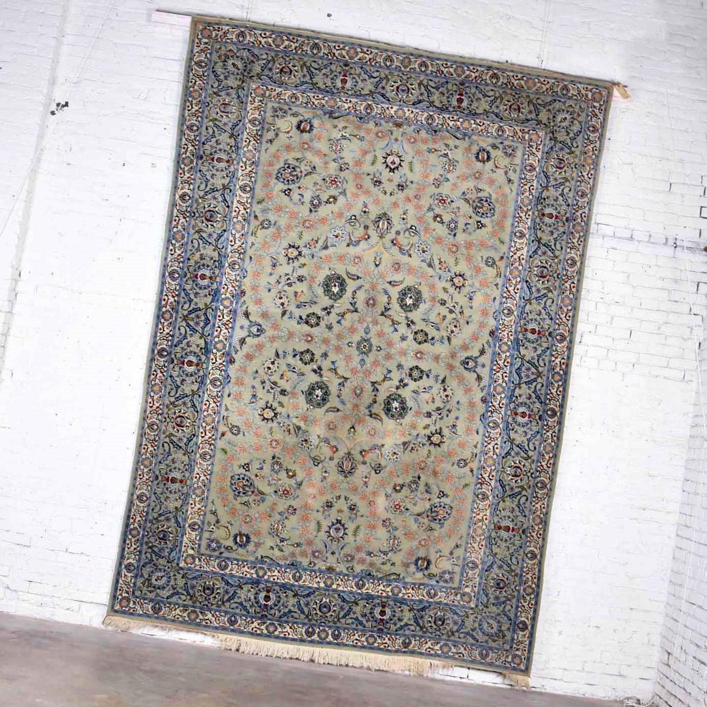 Handsome large 12’3” x 8’ 9.5” handmade Persian wool Tabriz style rug with a light teal green ground and blue, red, pink, and cream flowers and vines. It is in wonderful vintage condition. It has been professionally cleaned but may still have small