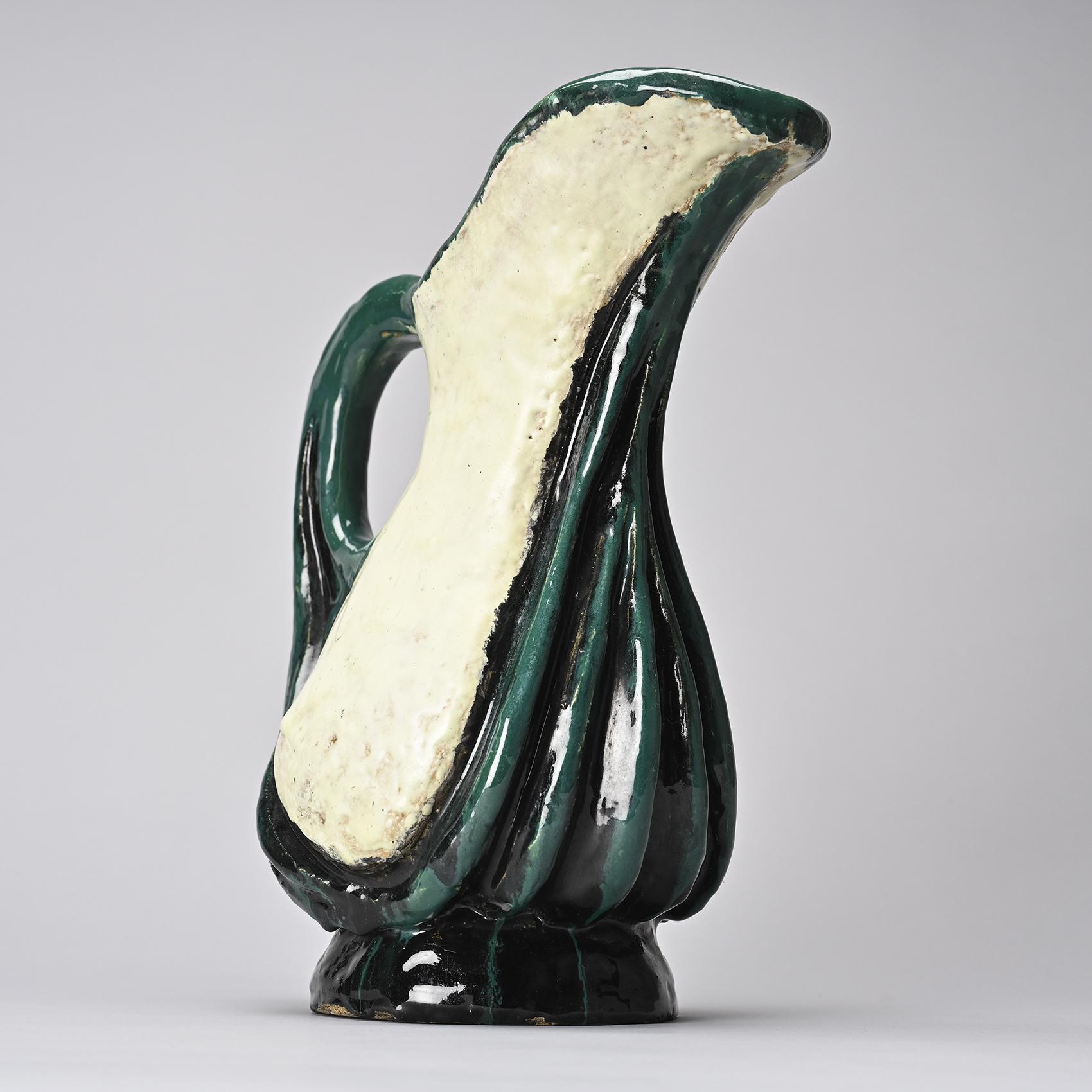 Pièce Unique façonnée à la main par Alice Colonieu

Rare pichet à large anse et bec verseuren terre chamottée émaillé vert et blanc.

Cachet circulaire de l'artiste en creux au revers de la base.

Alice Colonieu (1924-2010) est une céramiste et