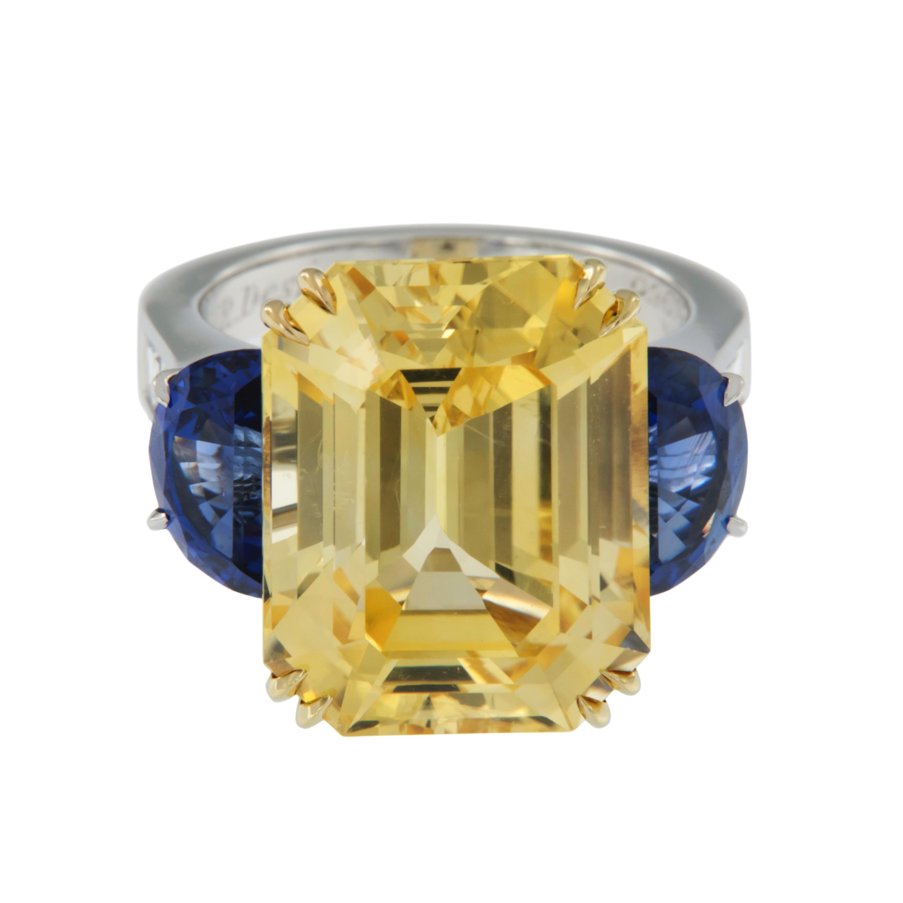 Hail to the Victor Valiant - or Hail to this One of a Kind Impressive ring! Handmade in New York, this spectacular ring houses a massive 22.37 carat yellow sapphire, perfectly flanked by moon cut rich blue sapphires (4.21 Cttw) and topped off with