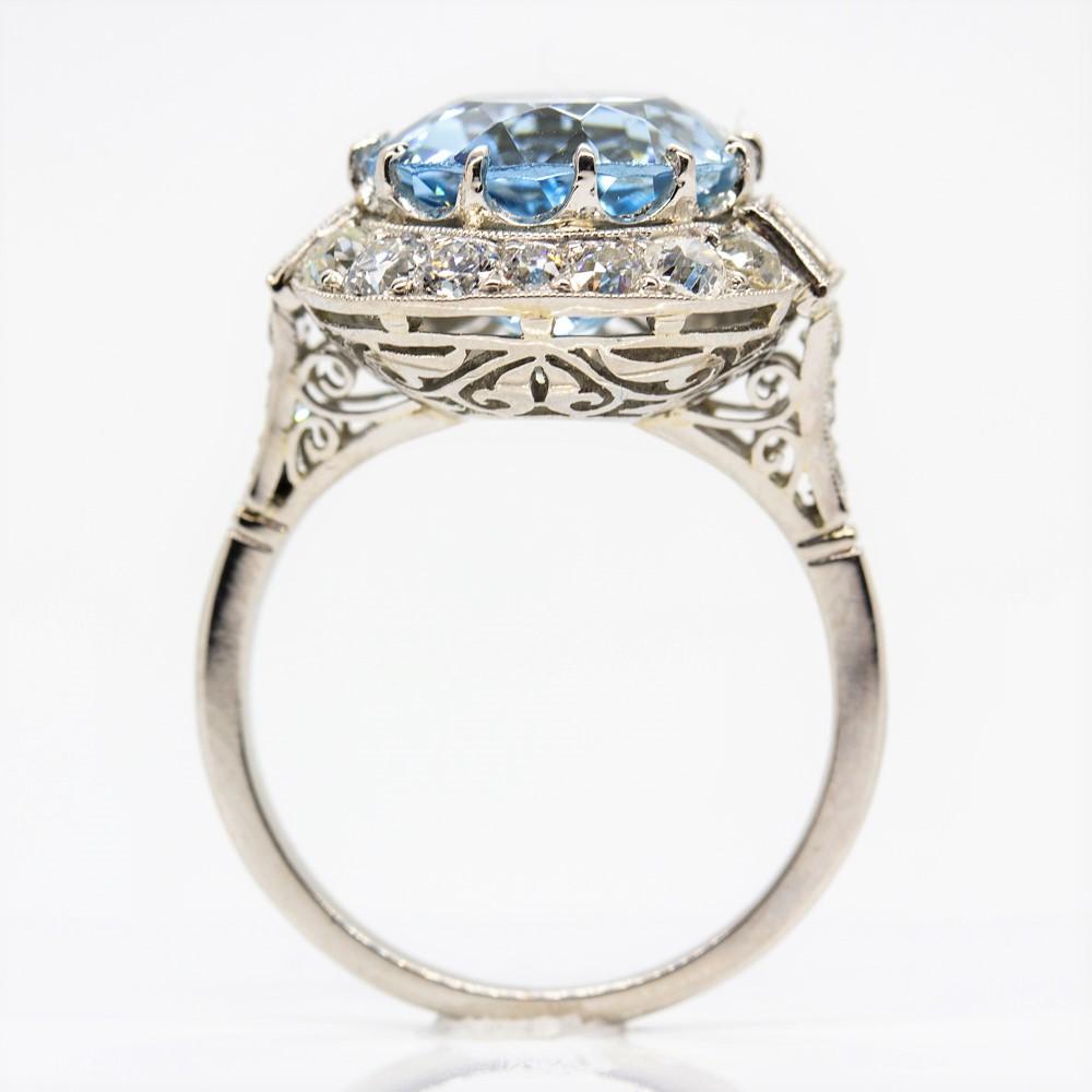 This stunning handmade ring is centered with one natural aquamarine that weighs 6ctw.
The flawless central gemstone is surrounded by 20 old mine cut diamonds of H-VS2 quality that weigh 0.90ctw.
This enticing piece of jewelry also displays 4 French