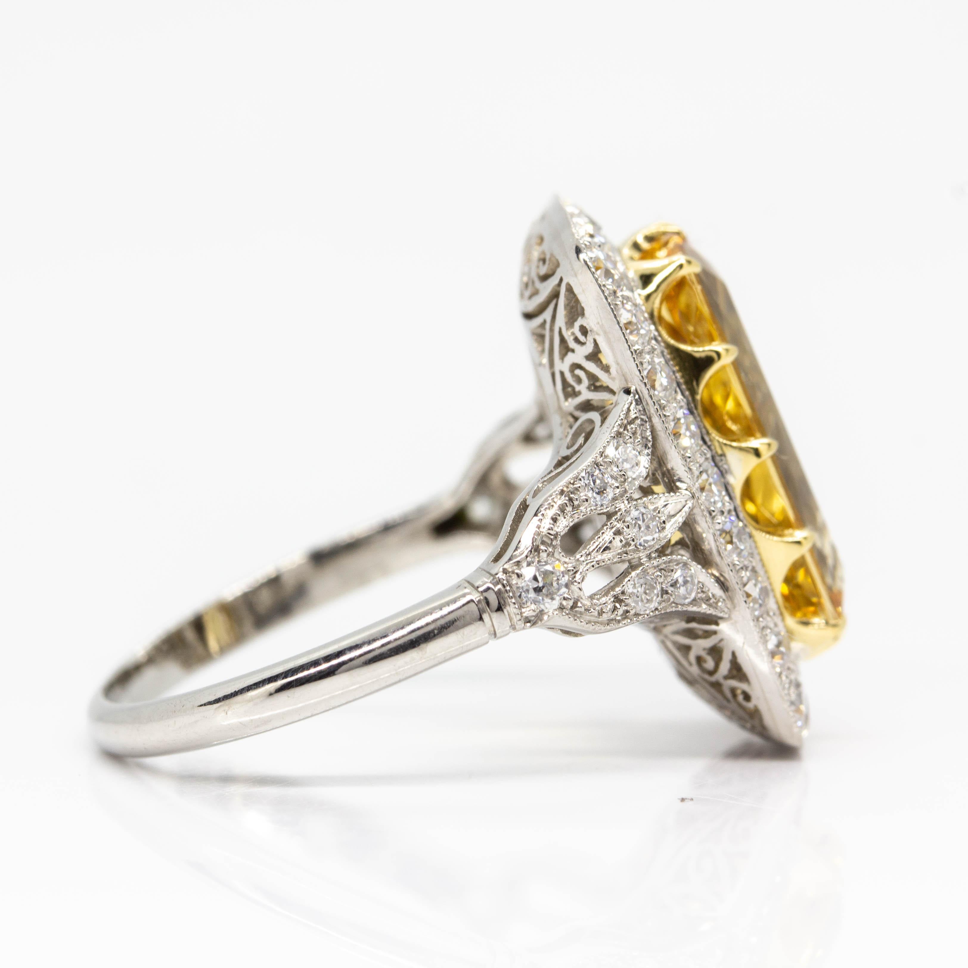 One yellow topaz weighing 4.75ctw radiated from the center of this exquisite ring.
Its stunning halo that surrounds the central stone is composed of 0.70ctw of 34 H-VS2-quality old mine cut diamonds.
The dazzling diamonds continue glittering on the