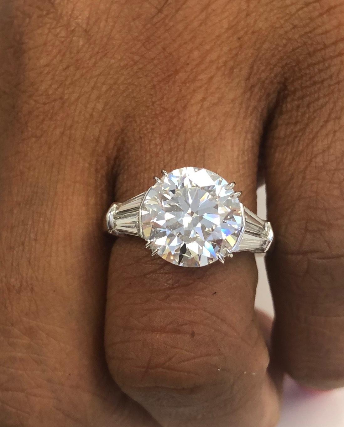 This fabulous handmade Platinum Ring for the very special center Diamond of 5.02 carats with a GIA report, EVS1, X,X,VG,N
accompanied with a total of four Tapered Baguette Diamonds 1.04 carats.
This is the kind of ring you would only ring in some of