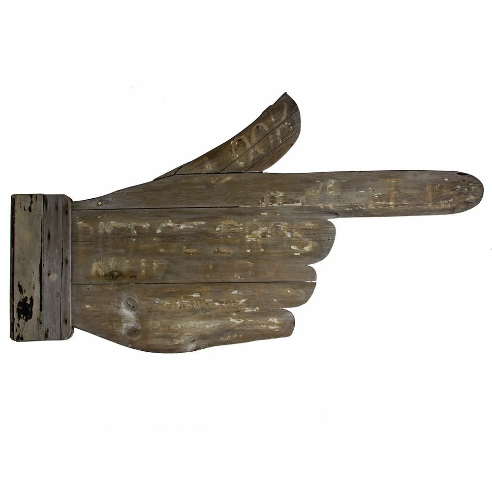 An advertising classic! This oversized handmade pointing finger retains remnants of its original paint. Early 20th century.