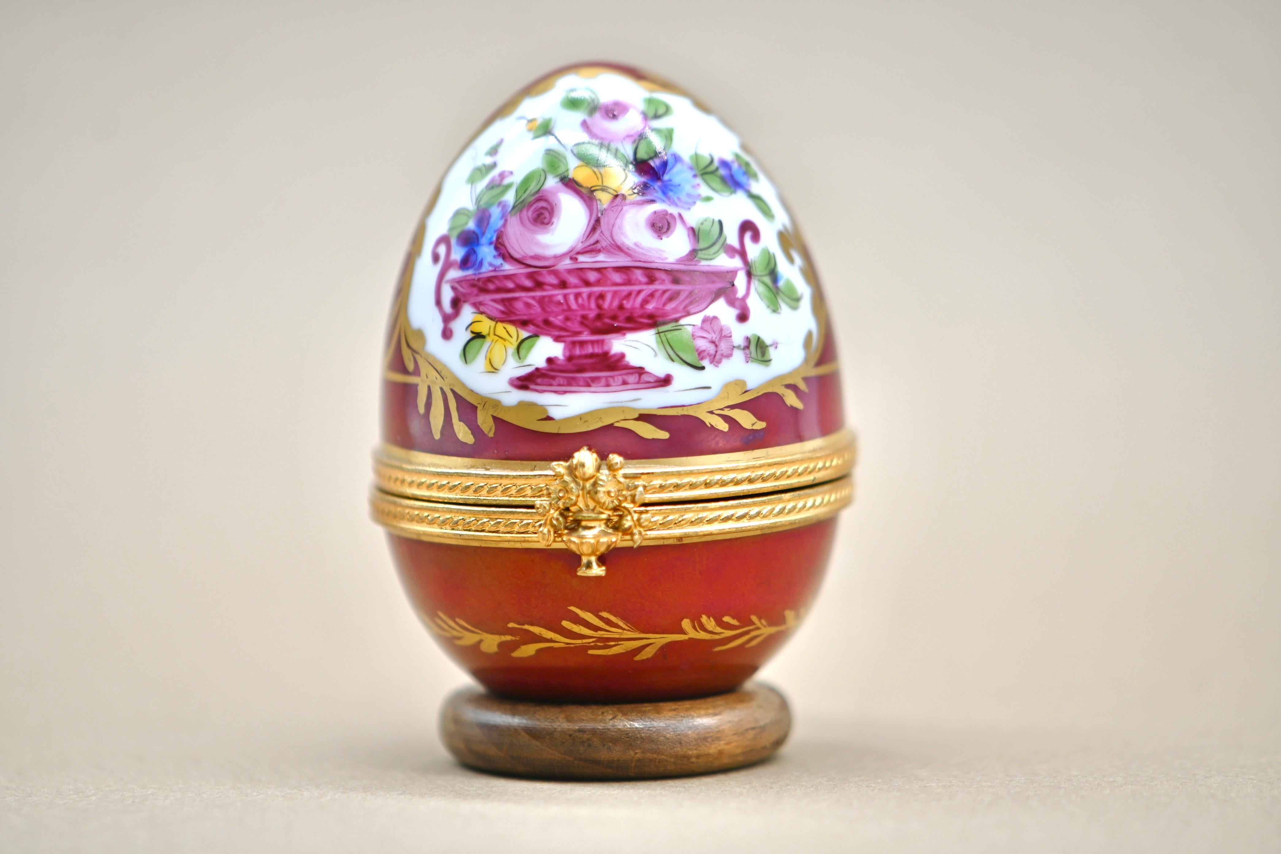 Discover this wonderful egg-shaped clock, crafted in Limoges porcelain and finely hand-painted, signed by the artist. The delicate painting depicts a bouquet of spring flowers, adding a touch of freshness and elegance to this precious object. The