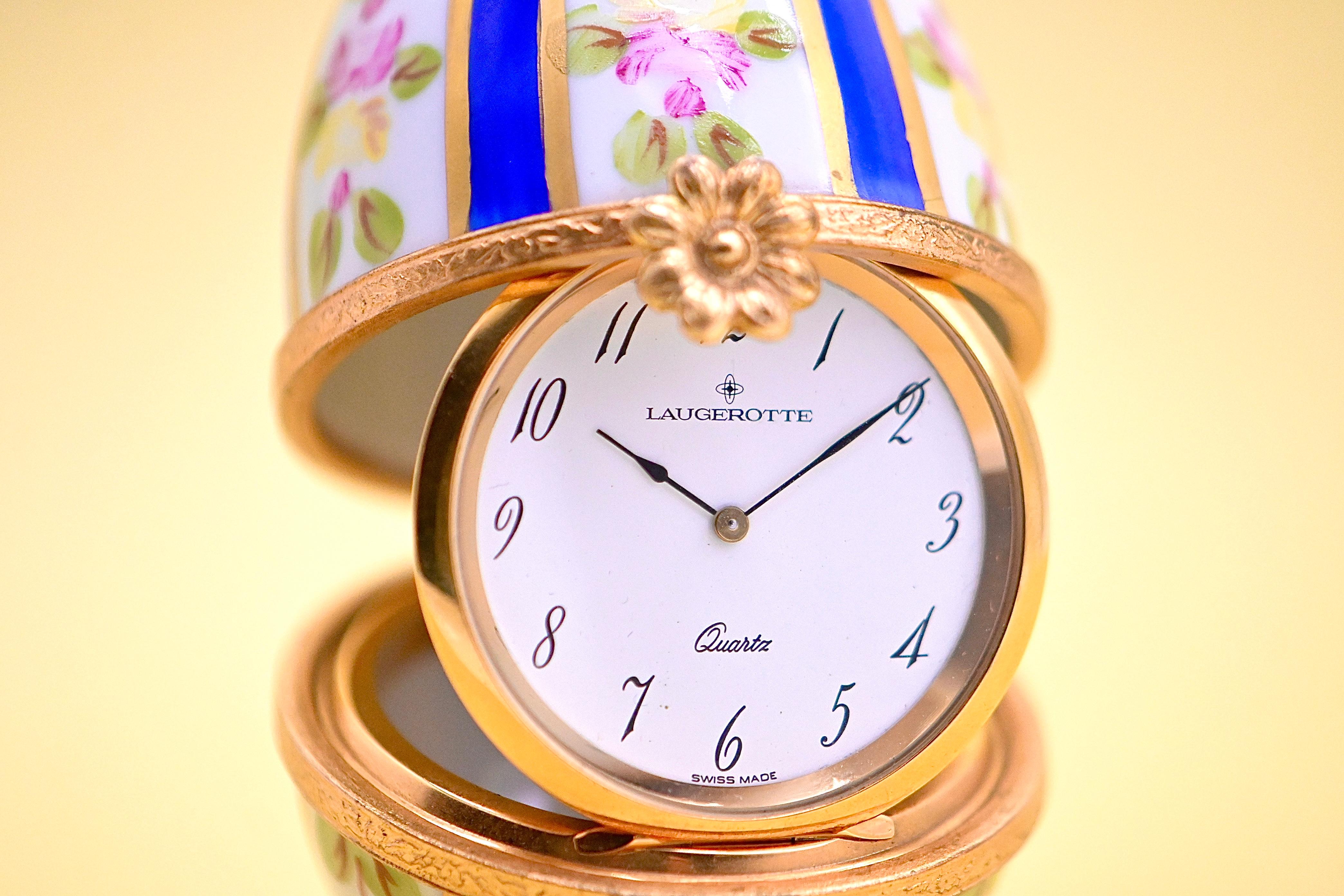 Discover this wonderful egg-shaped clock, crafted in Limoges porcelain and finely hand-painted, signed by the artist. The delicate painting depicts spring flowers, adding a touch of freshness and elegance to this precious object. The egg can be