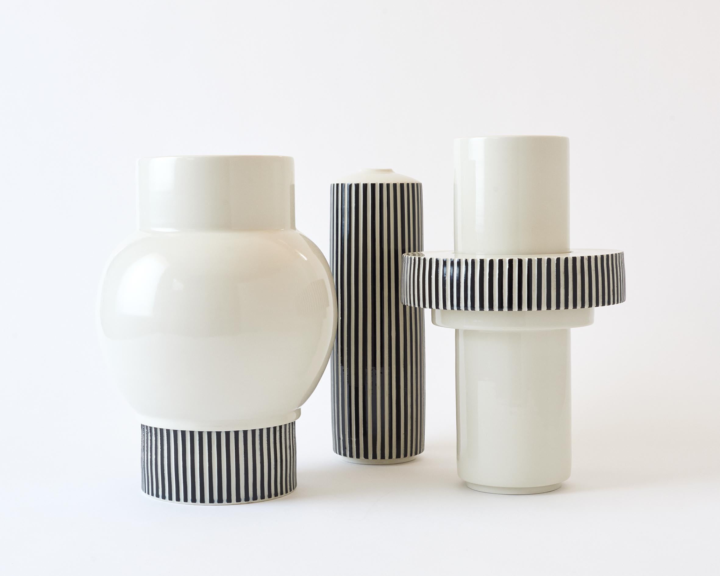 This hand-thrown porcelain vase is a contemporary and functional stand out piece. Modular vase with one ring. The base is glossy white porcelain, one ring with hand carved stripes. The vase has a size of Diameter 20cm, Height 33cm. 

The first Atlas