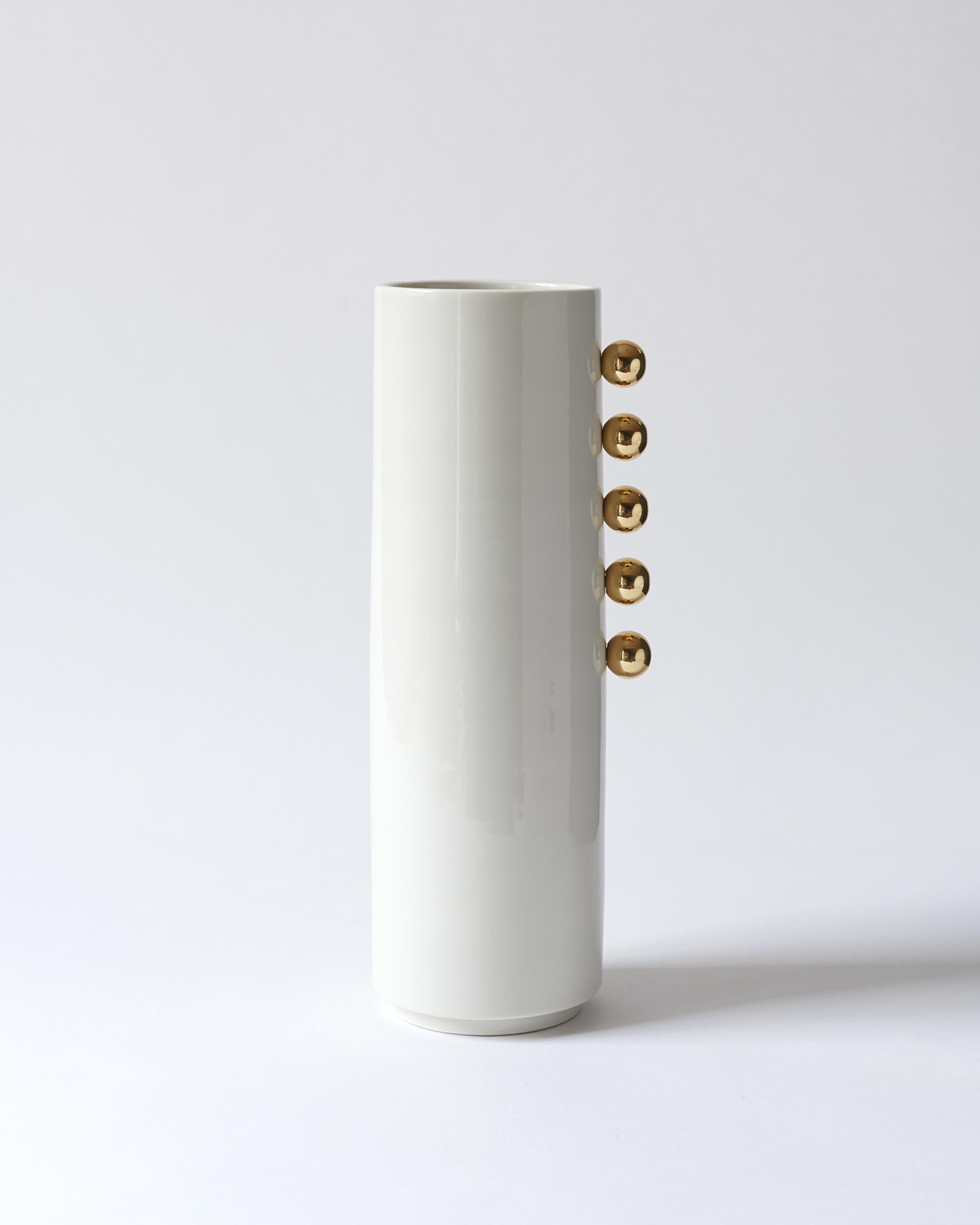 This hand-thrown porcelain vase is a contemporary stand out piece.
The vase is made of glossy white porcelain with five polished Brass Balls and has a size of diameter of 9.5 cm, height 30 cm. 

The first Atlas Crafts collection is thrown by hand