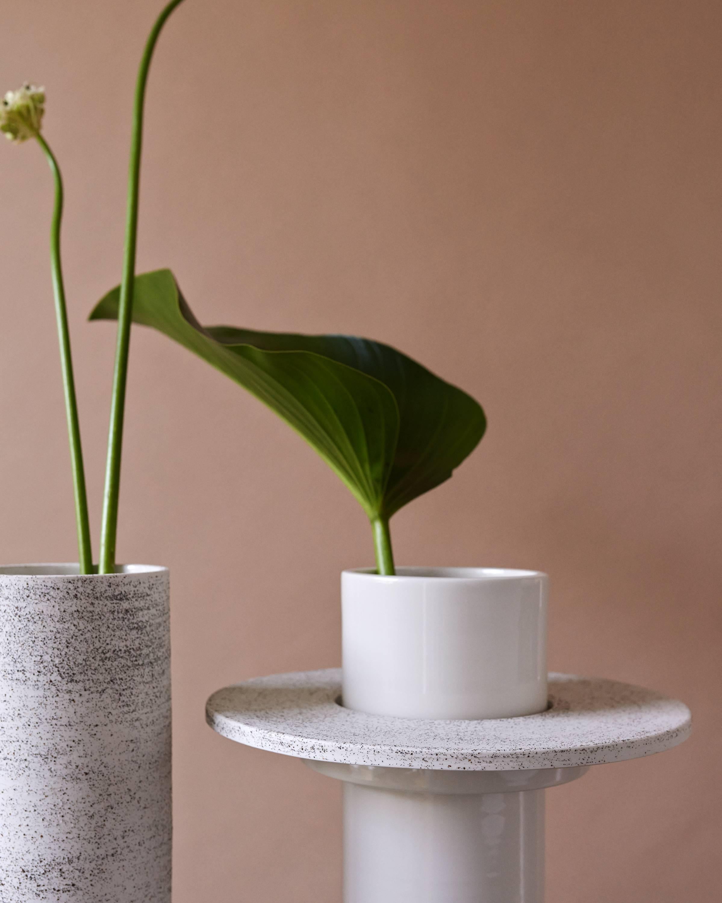 This hand-thrown porcelain vase is a contemporary and functional stand out piece. 
The vase is made of matt white porcelain with volcanic sand from Balis island shores. The vase has a size of diameter of 10cm, height 27.5cm. 

The first Atlas