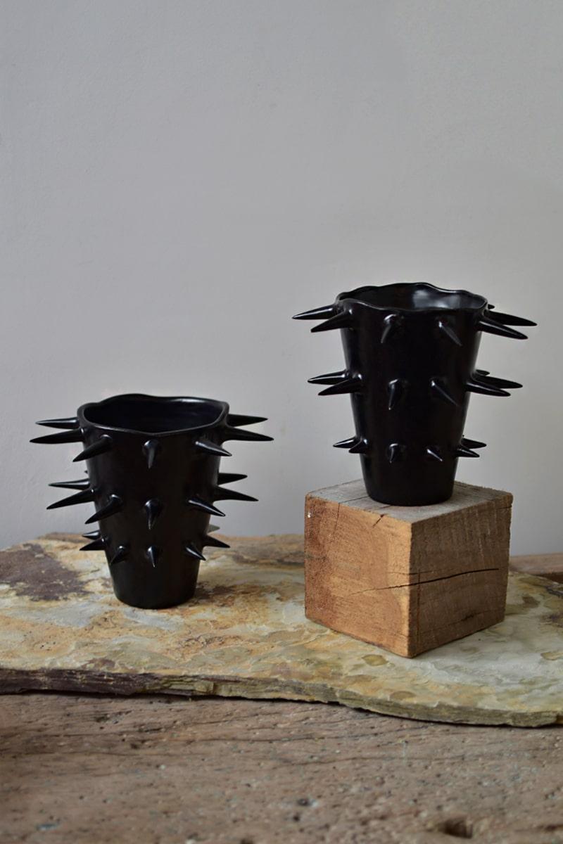 Magnifique vase décoratif noir à pointes, parfait pour mettre en valeur vos fleurs préférées. Offrant une perspective unique sous tous les angles, ce vase en céramique fabriqué à la main brouille la frontière entre fonctionnalité et ornement.