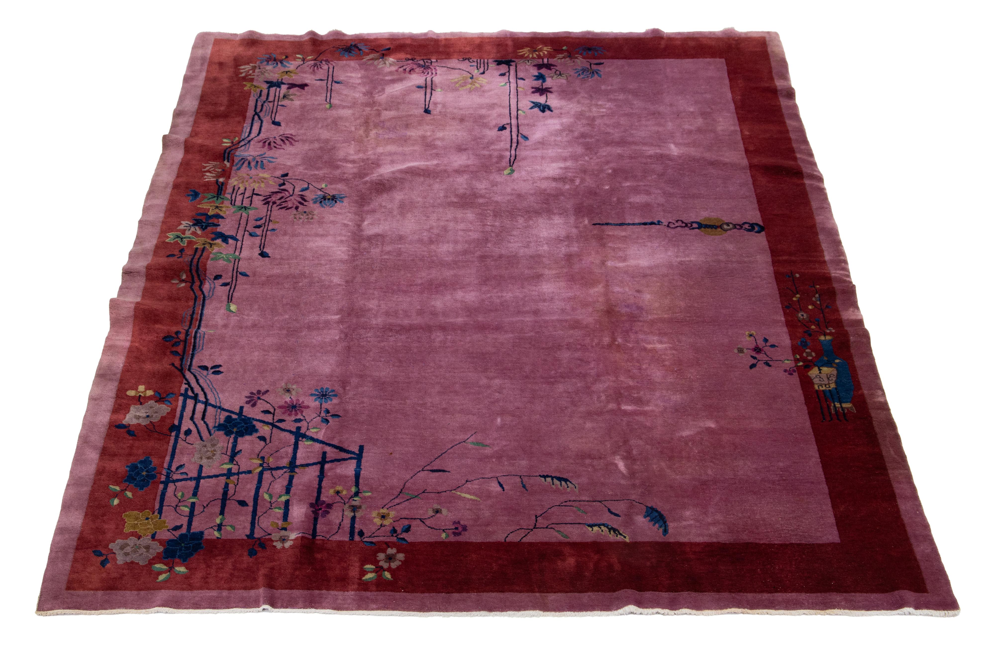 This is an Antique Chinese Art Deco rug, hand-knotted from wool with a purple background. It features a multicolor floral design with a red border.


This rug measures 9'1