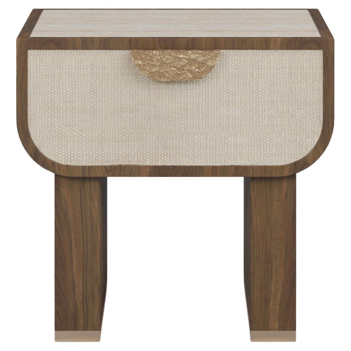 La table de nuit RAE est une fusion raffinée de textures naturelles et d'artisanat moderne. Encadrée dans un riche noyer, cette pièce respire la chaleur et la sophistication. Son tiroir de taille généreuse, doté d'une façade texturée, offre à la