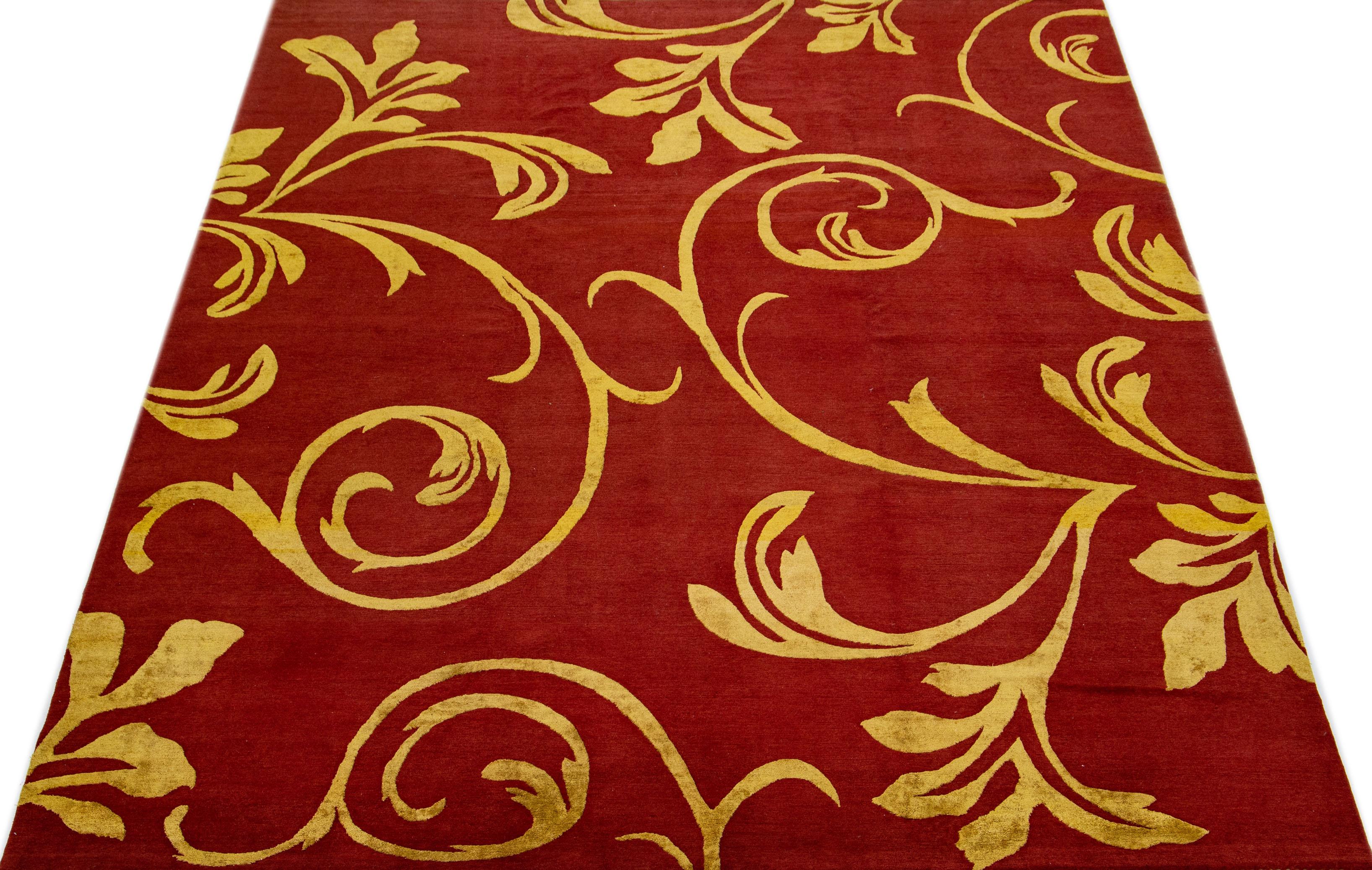 This exquisite Nepalese hand knotted wool rug boasts a captivating red color scheme and fine golden accents that complement its elegant all-over scroll design.

This rug measures 9' x 12'.
