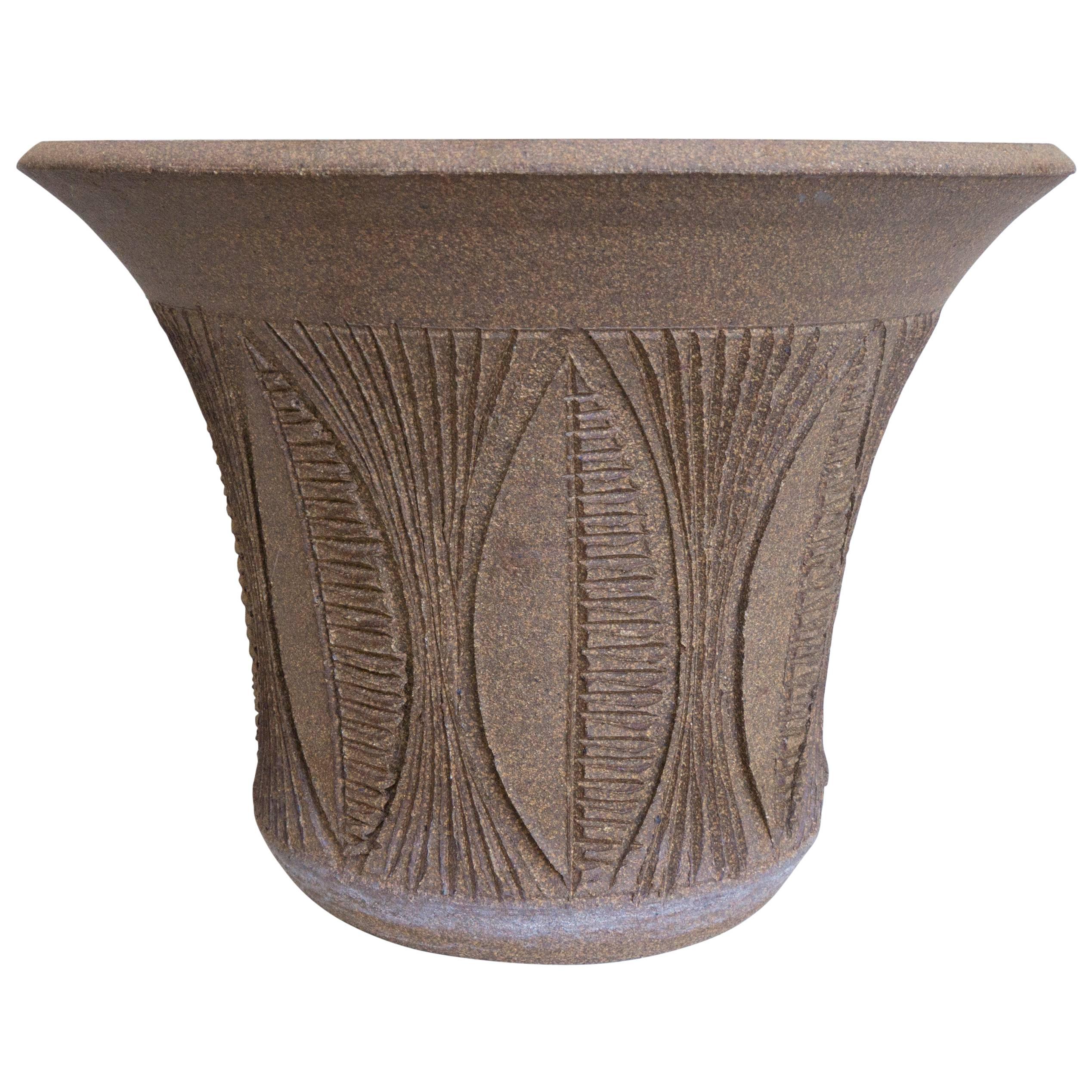 A small and detailed vessel, this handmade Maxwell has a rarely seen leaf design incised in the earth gender style clay. The inverted bell shape planter has a drain hole and is attention grabbing in a room. Certain to increase in value if cared for,