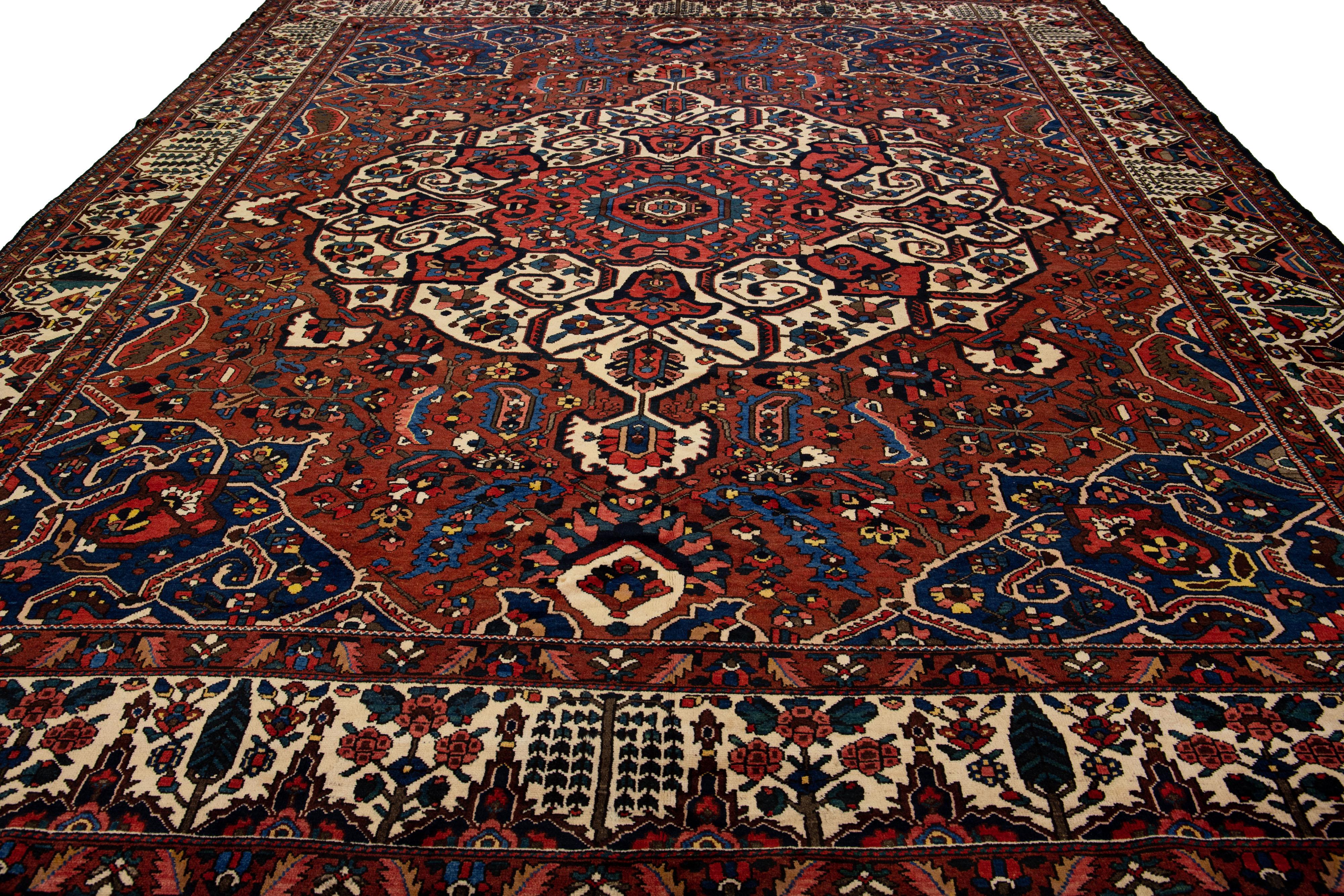 Beautiful Antique Bakhtiari hand-knotted wool rug with a red field. This Persian piece has an all-over multicolor accent in a gorgeous classic Medallion motif.

This rug measures 13'1